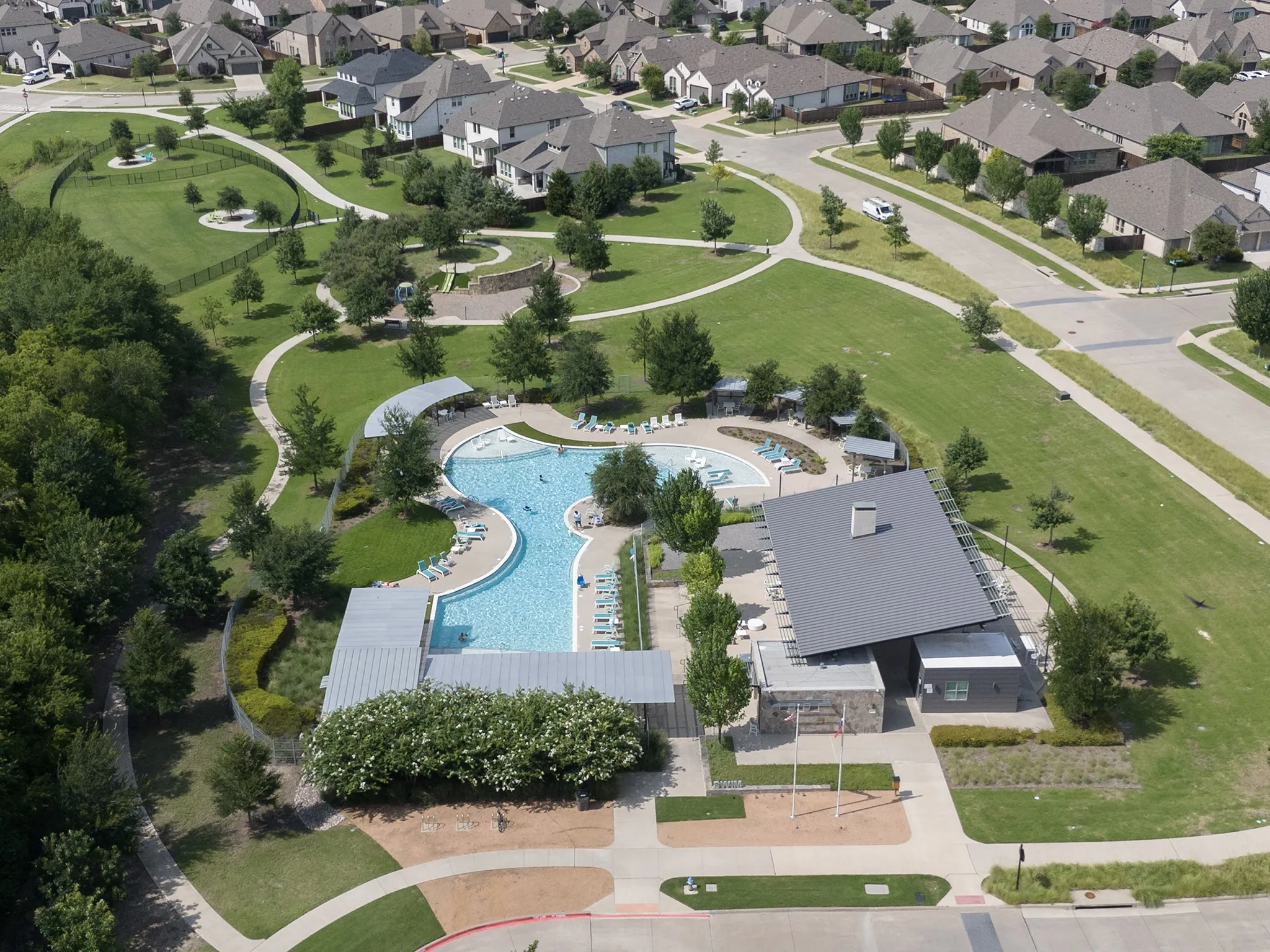 Community swimming pool with a modern clubhouse and ample lounge seating