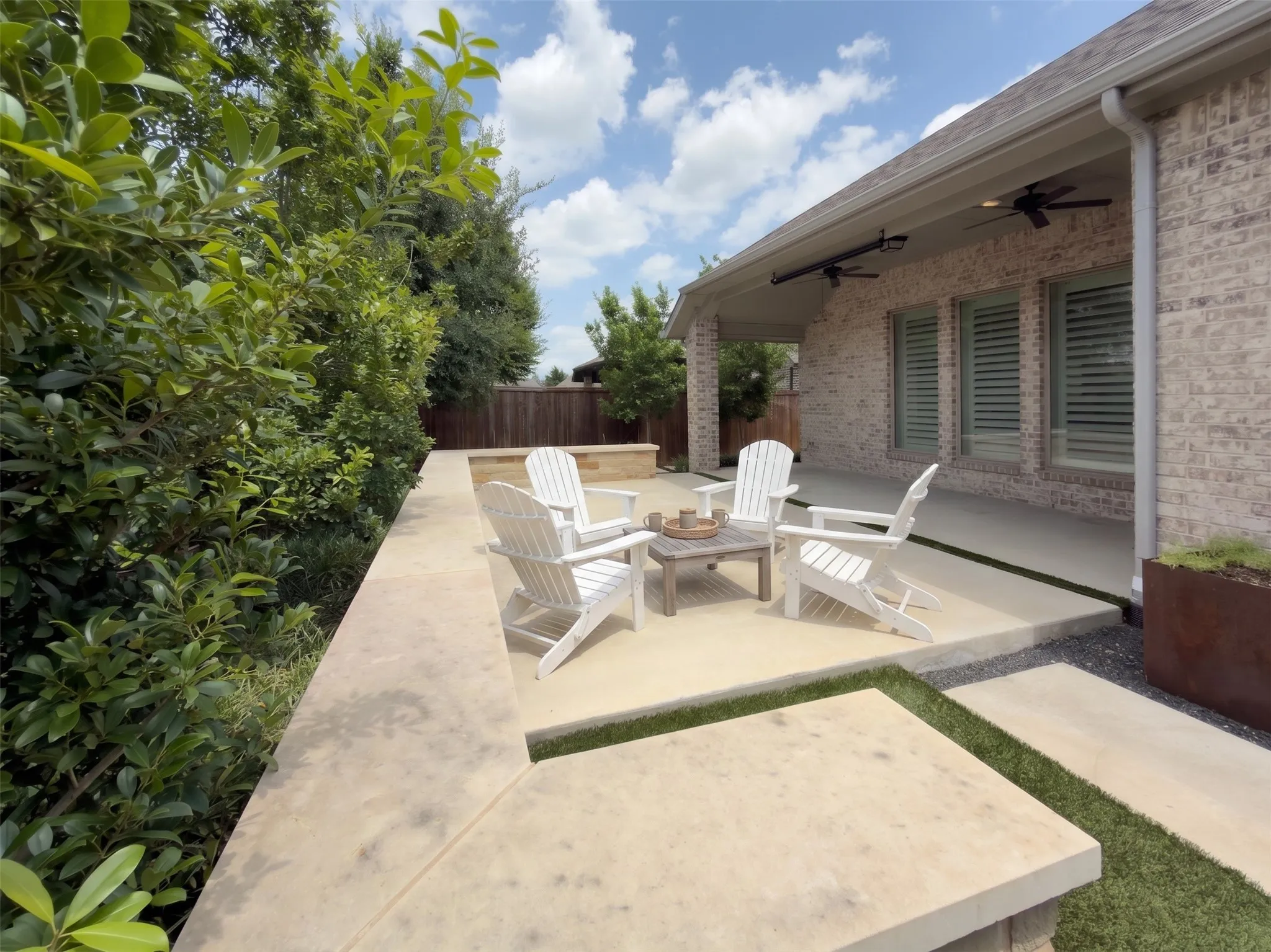Expansive patio with concrete surfacing, brick exterior, and recessed lighting