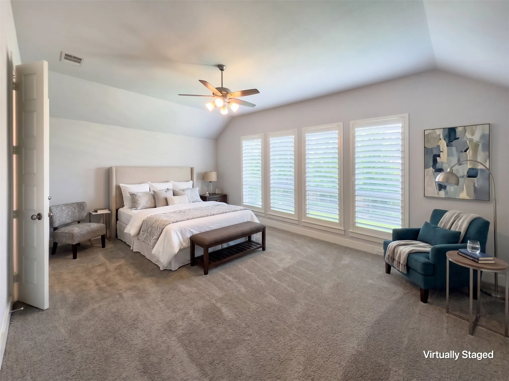 Spacious room featuring vaulted ceilings, a ceiling fan with integrated lighting, and carpeted flooring