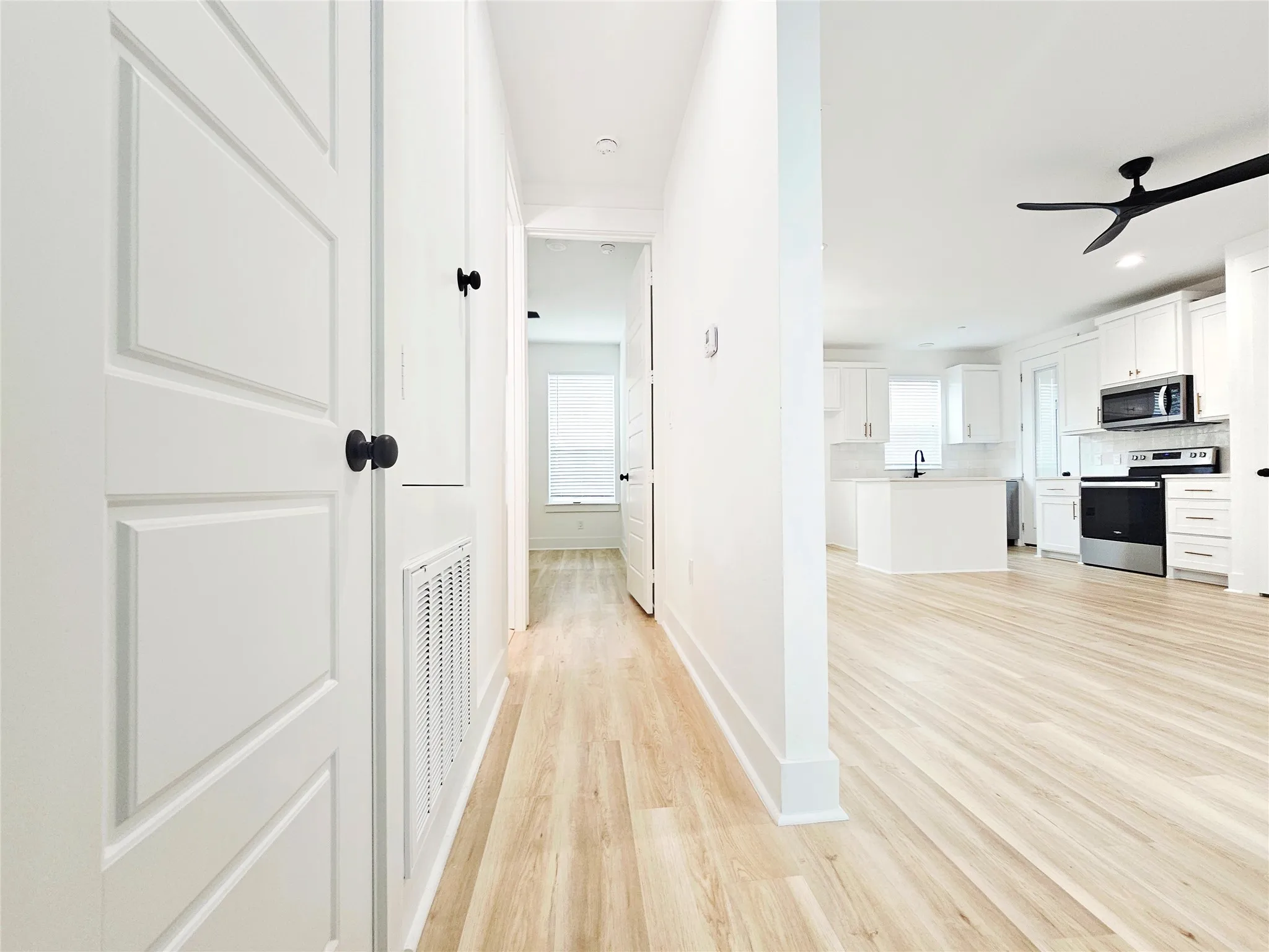 Corridor featuring a sink, light wood finished floors, baseboards, and recessed lighting