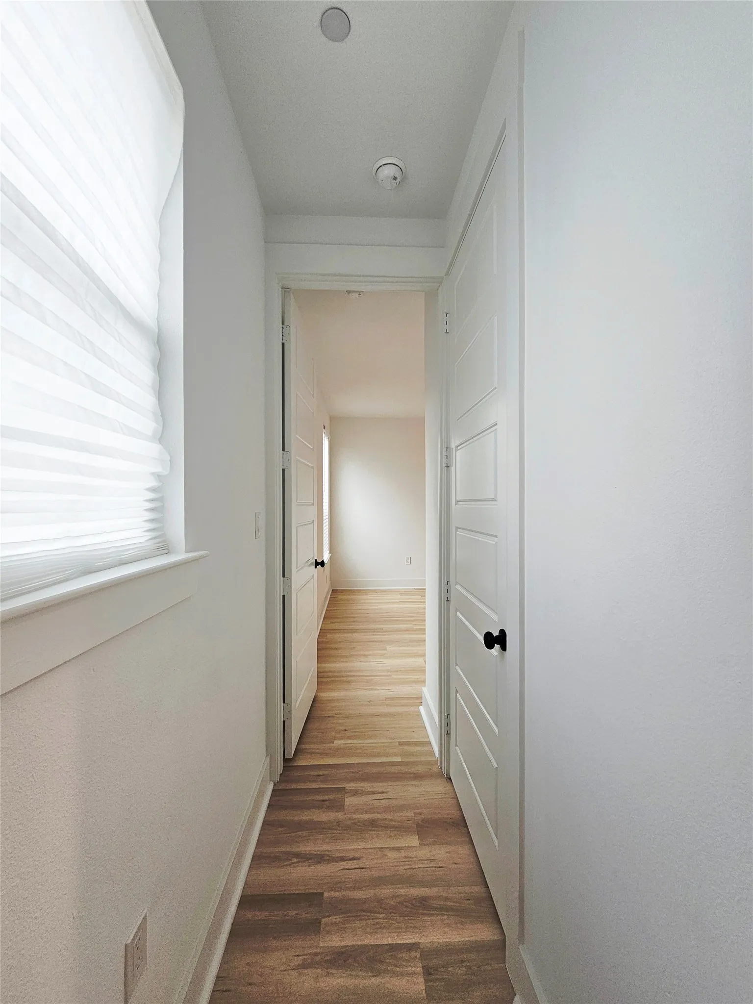 Hall with wood finished floors and baseboards