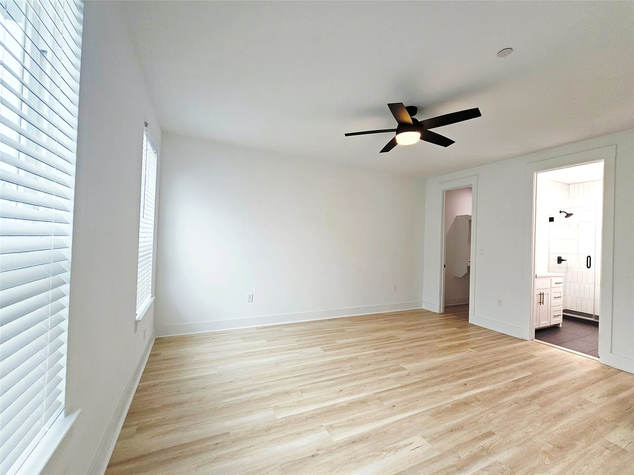 Unfurnished bedroom with multiple windows, light wood-type flooring, and baseboards