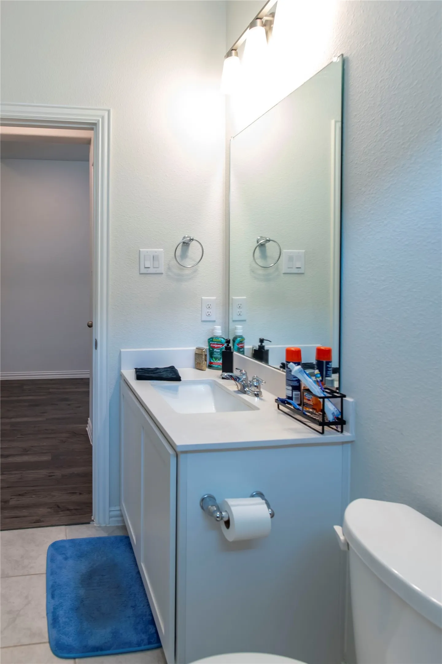 Bathroom vanity with an integrated sink, light-toned countertop, and recessed panel cabinetry