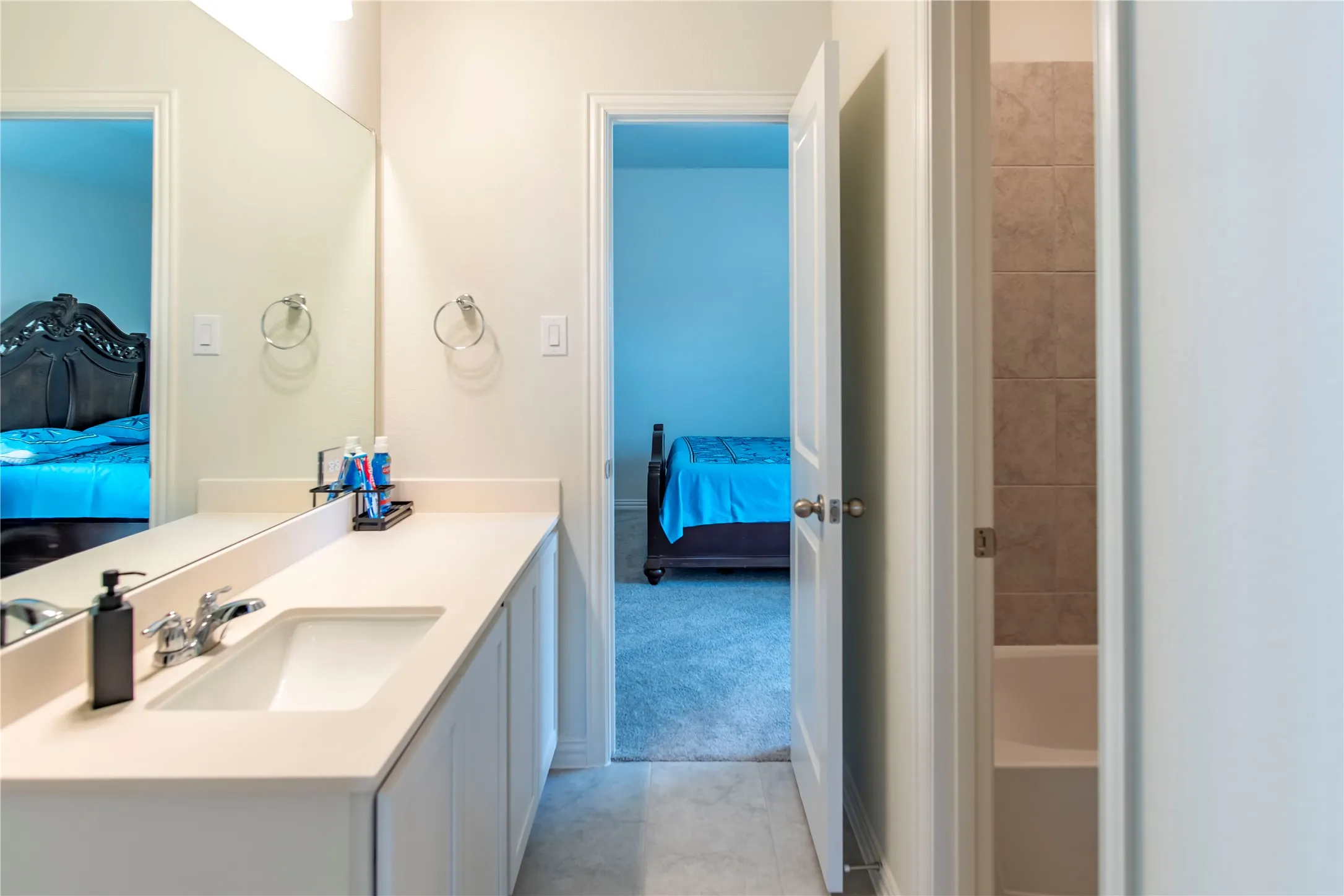 Bathroom vanity featuring a single basin, light-toned countertop, and undermount cabinetry
