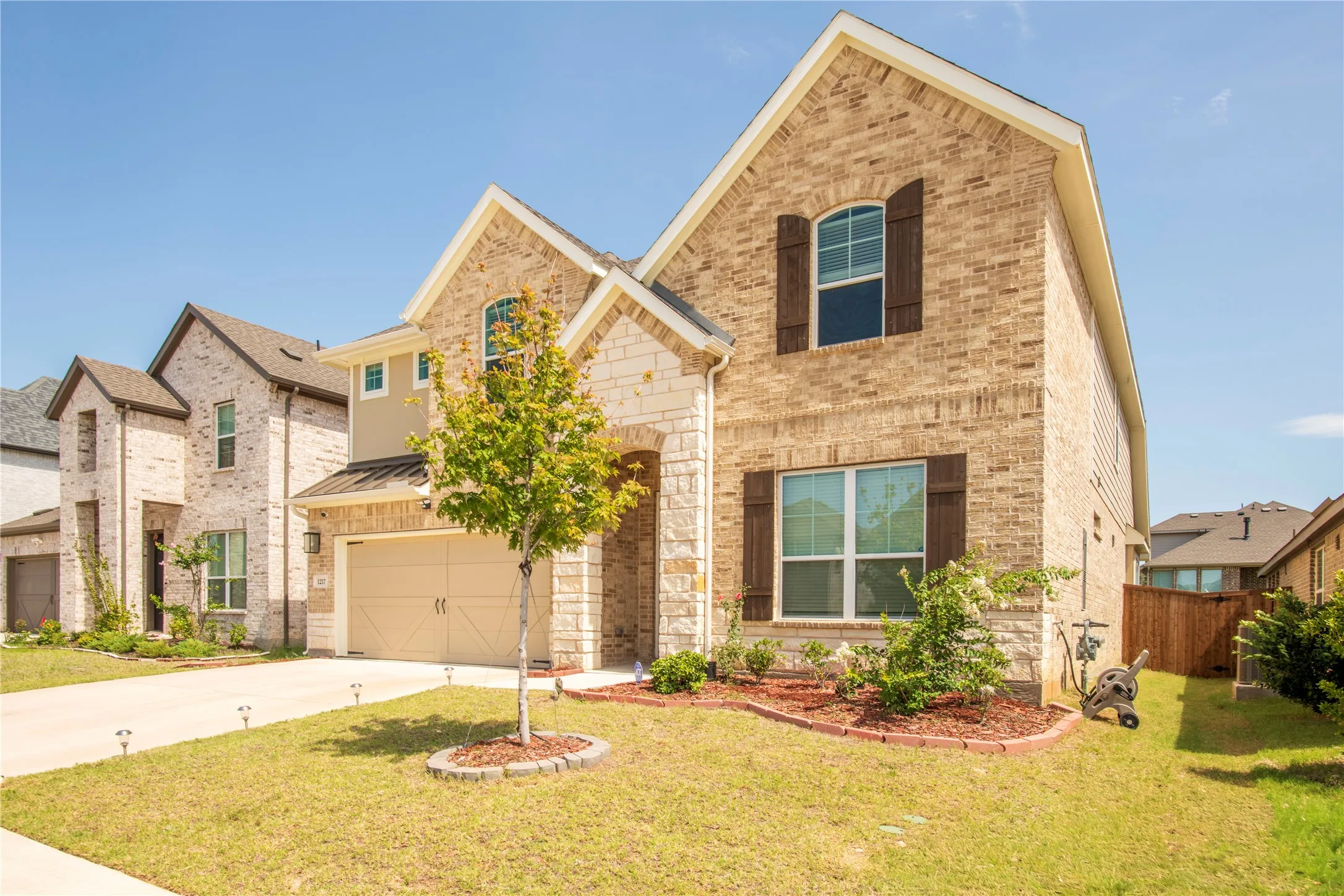 Two-story brick and stone exterior with decorative window shutters