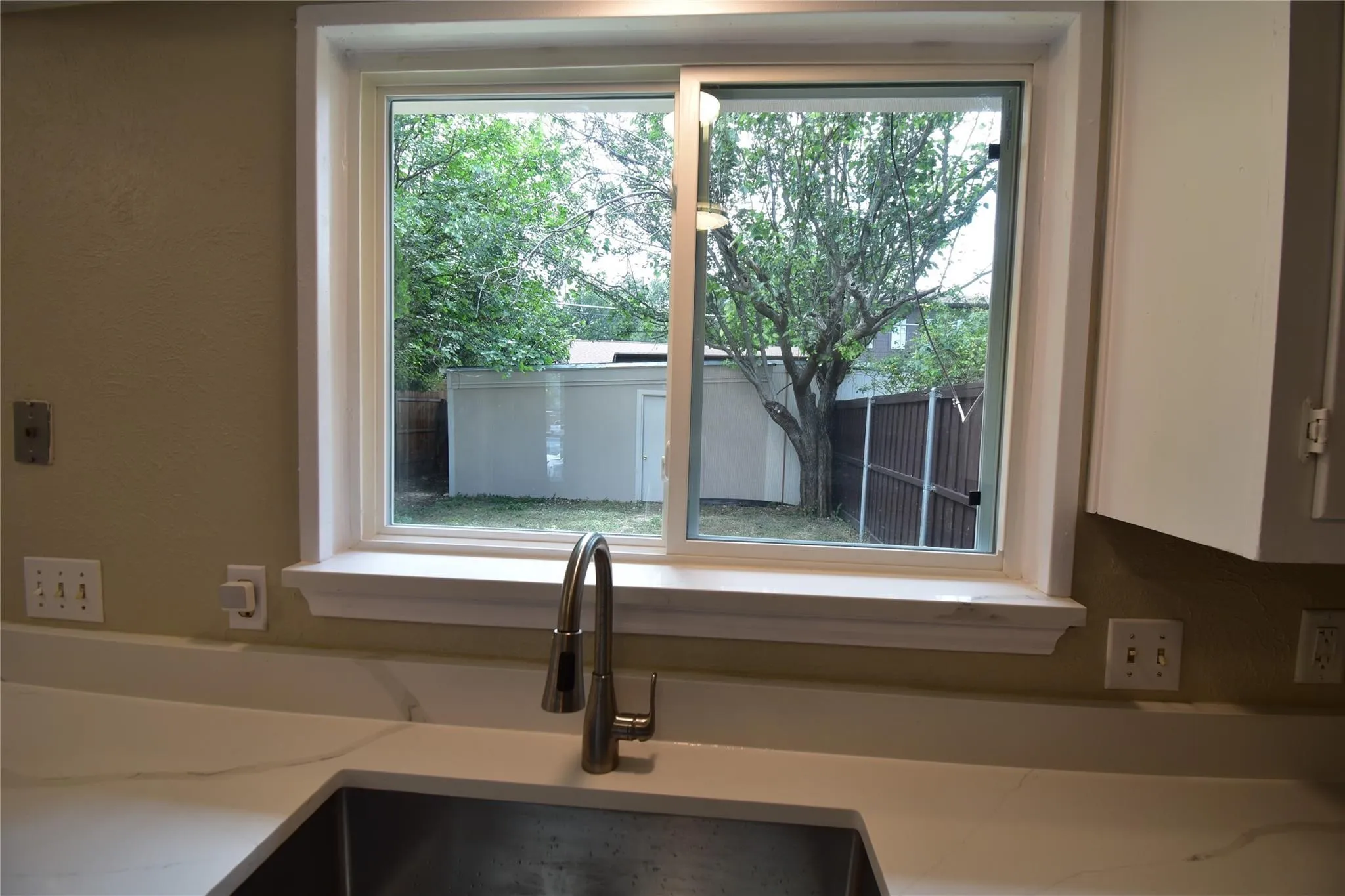 While doing the dishes, you can enjoy views of your family and friends having fun in the fenced private courtyard