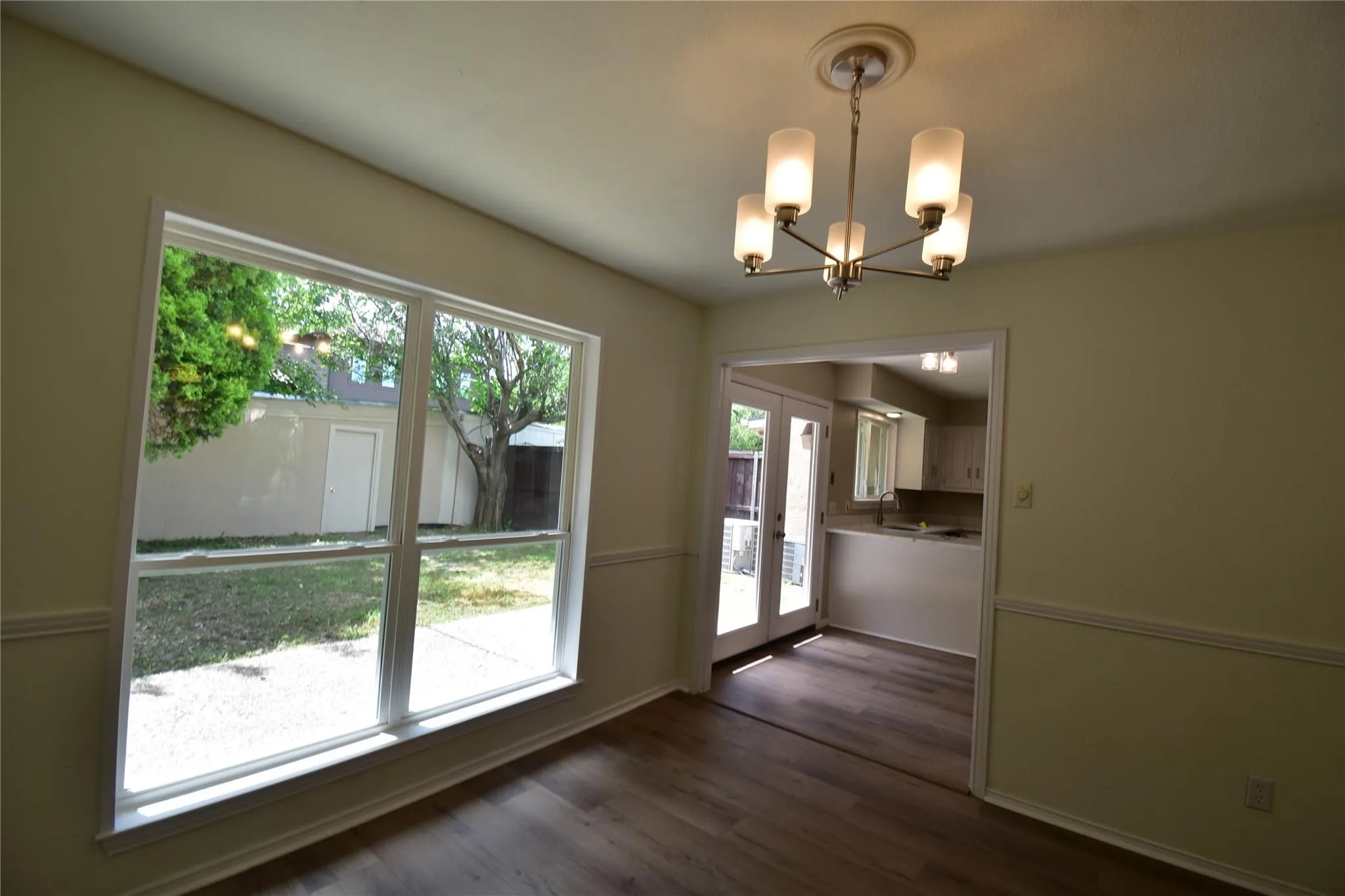Specious dining room with warn modern lights, elegant wood floor and large window to over look the private courtyard