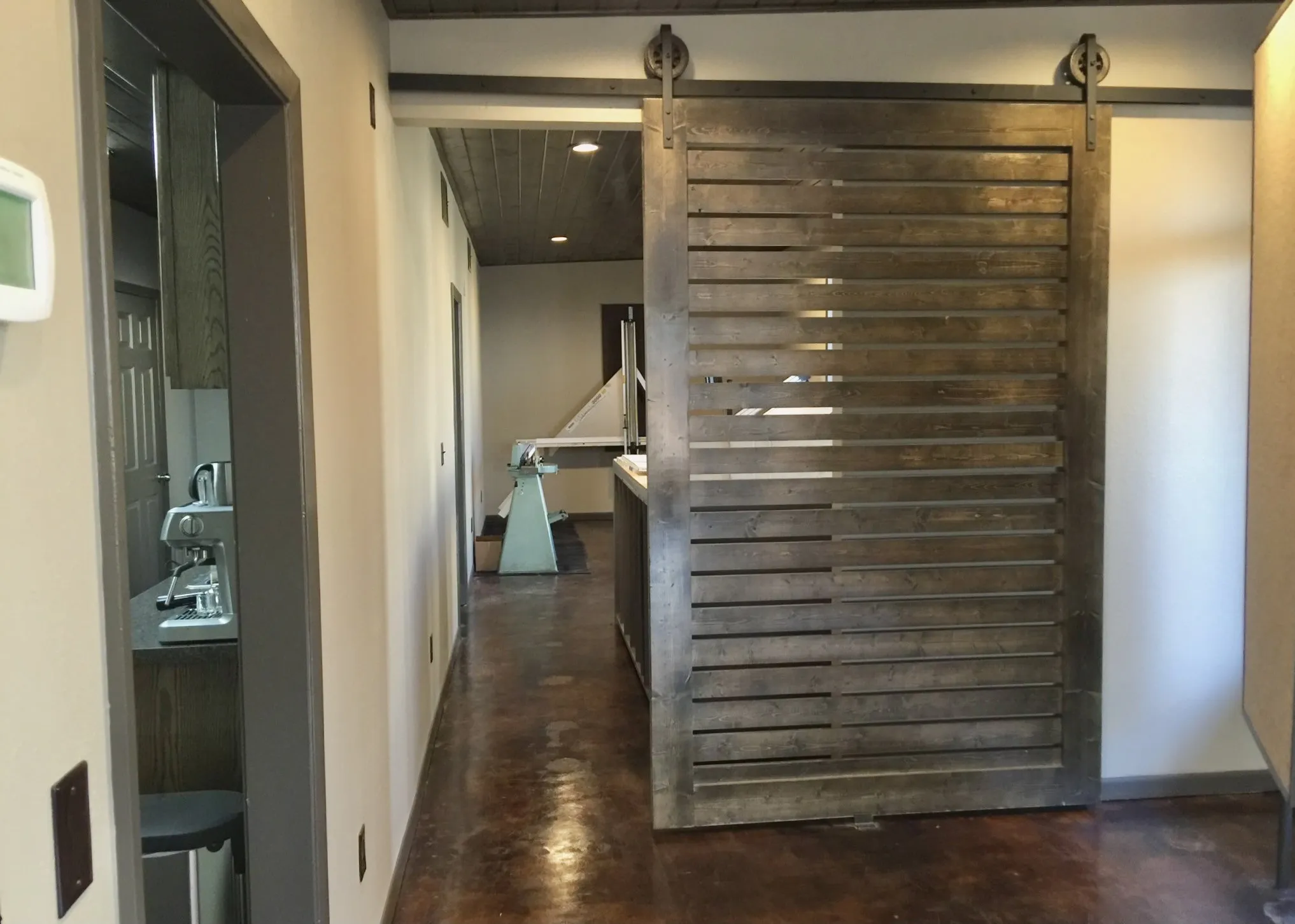 Slatted barn door featuring exposed track hardware