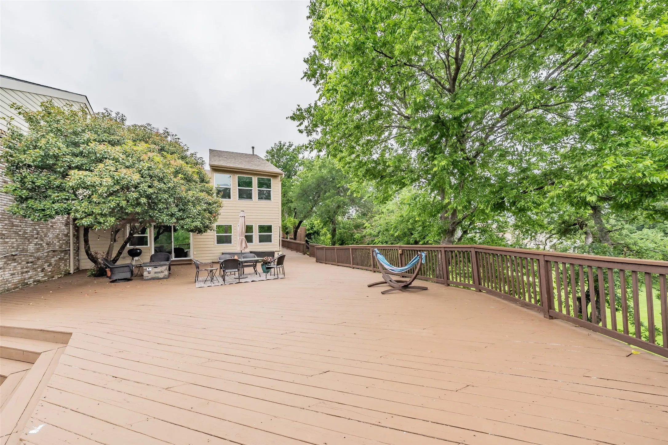 Expansive rear deck with multi-level design and wood railing, providing generous outdoor living space