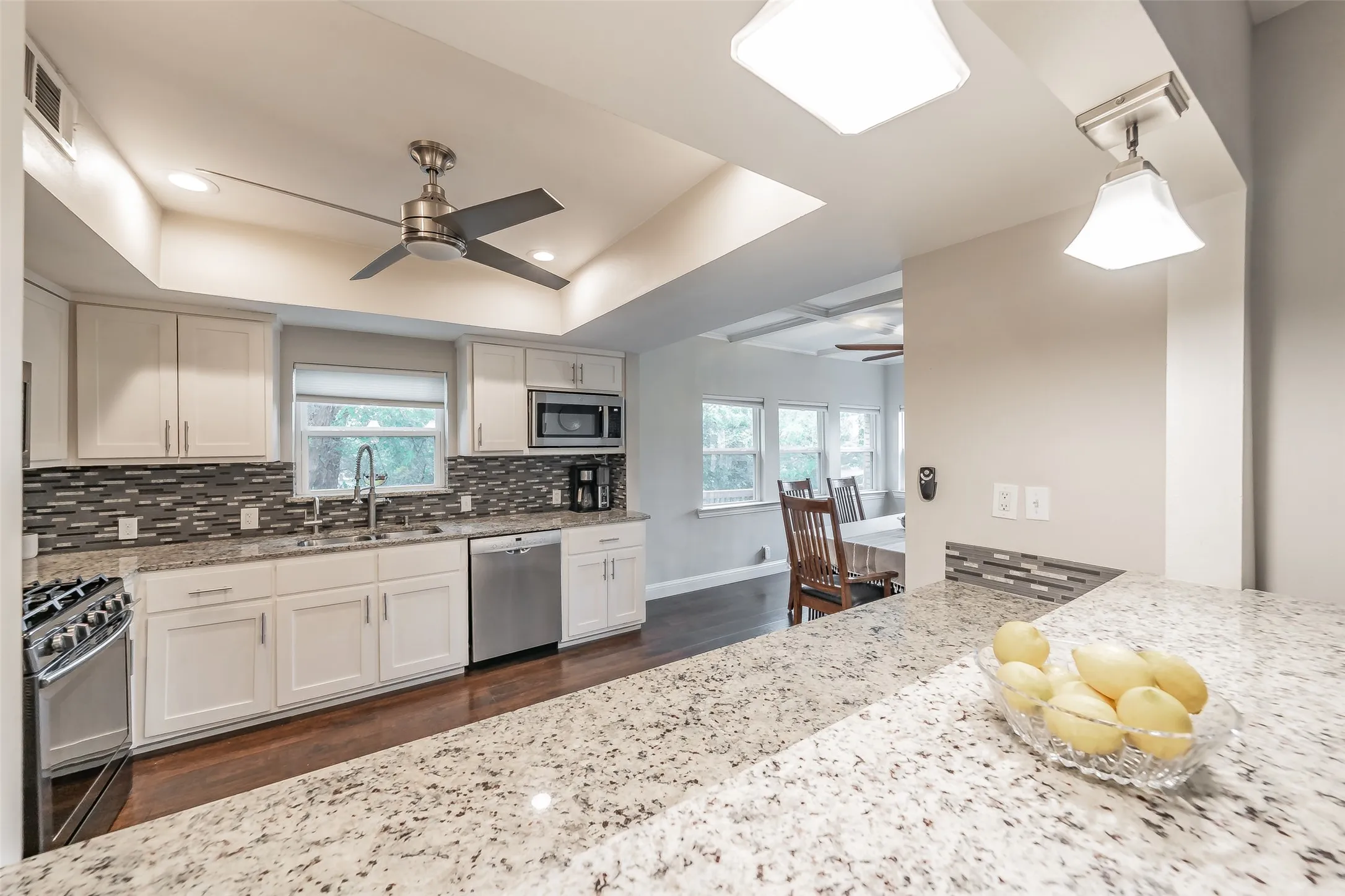 Modern kitchen with white cabinetry and dark wood-finish flooring