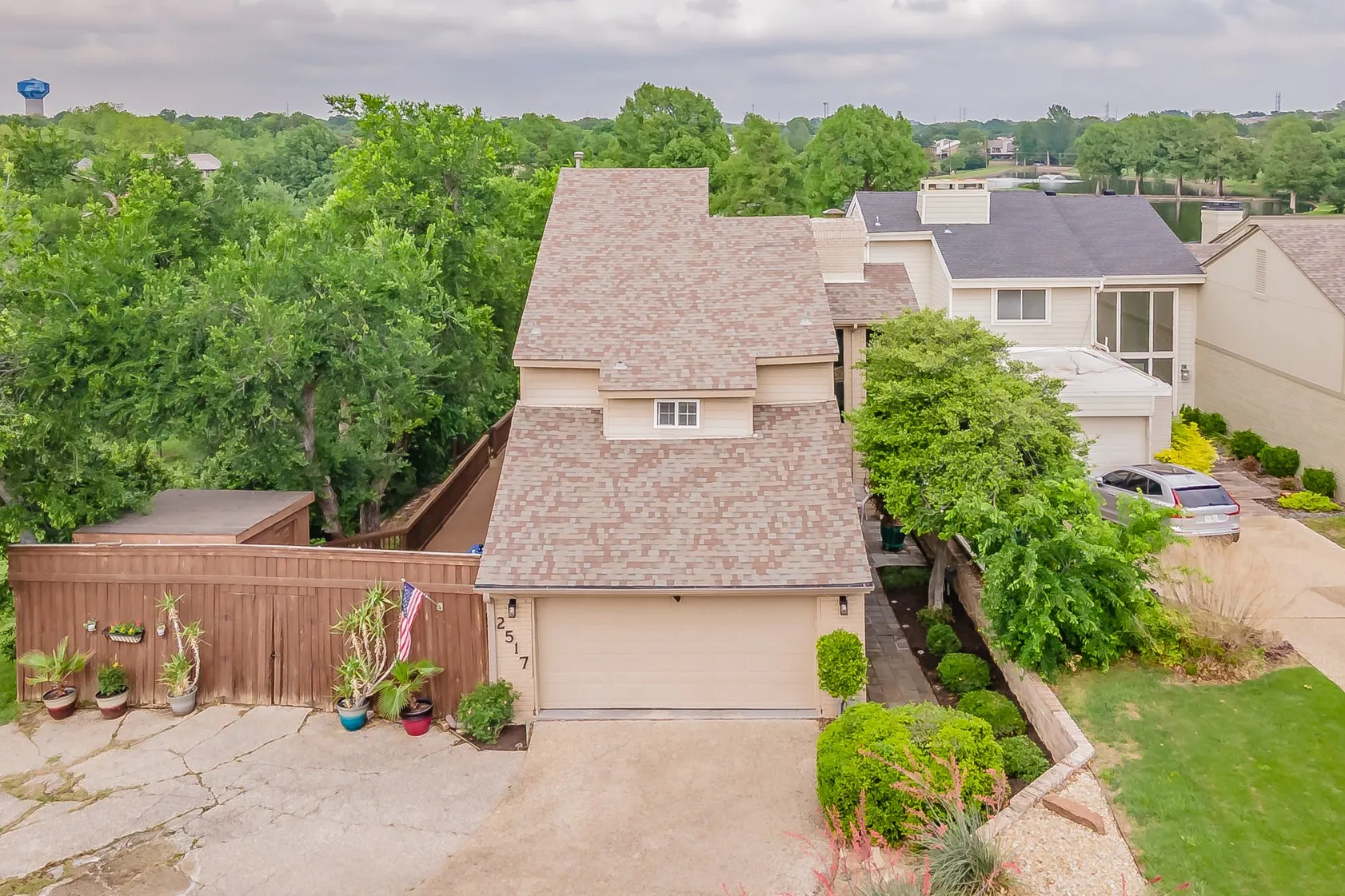 Two-story residence featuring a neutral exterior, attached garage, and a peaked shingle roof