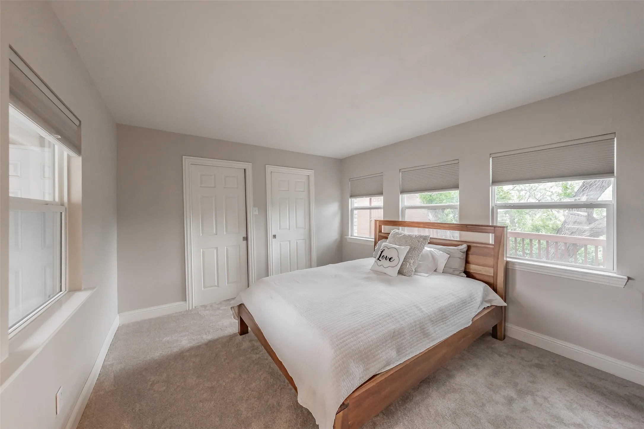 Carpeted room with multiple windows featuring window treatments
