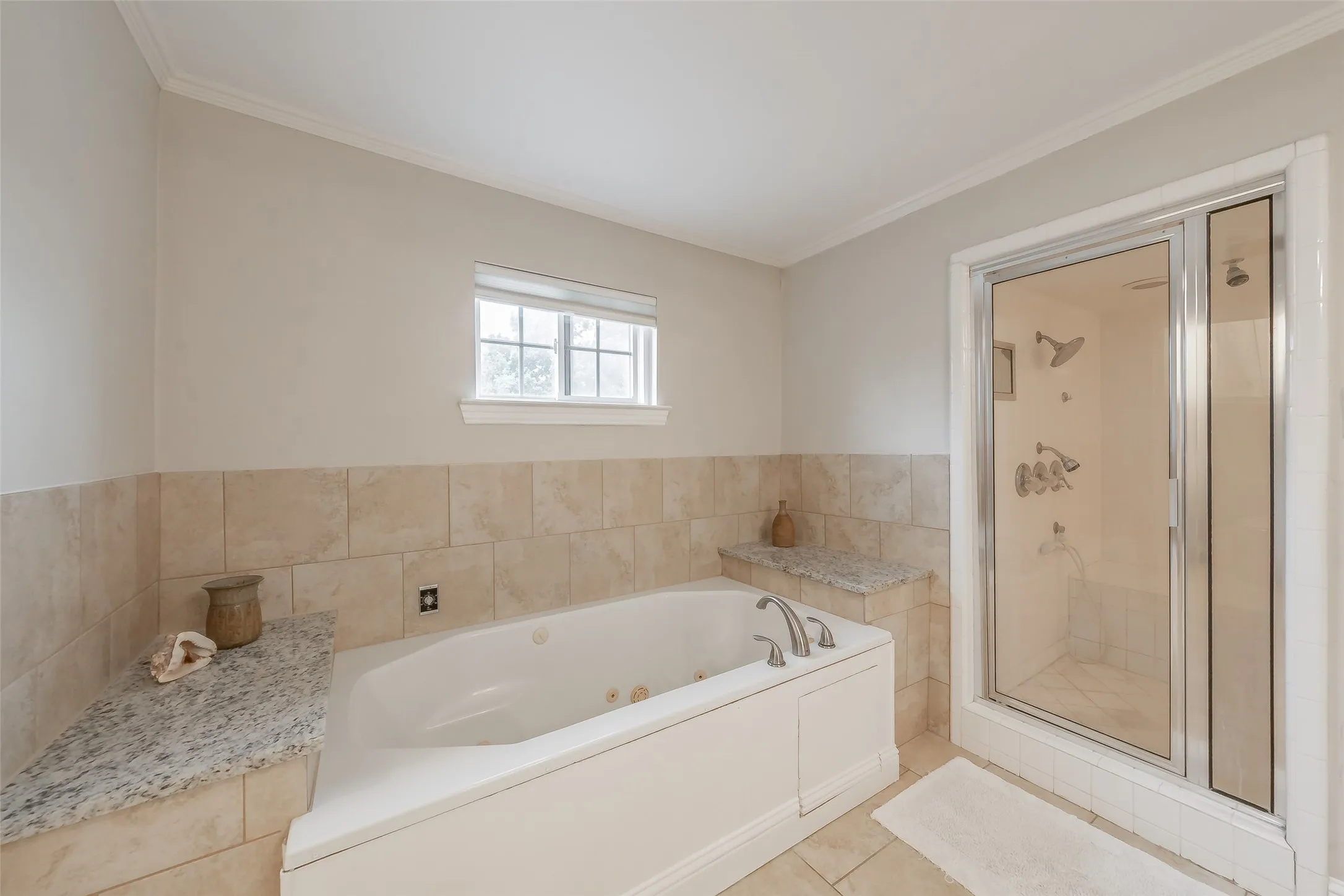 Soaking tub with a tiled surround and granite-finish counter space