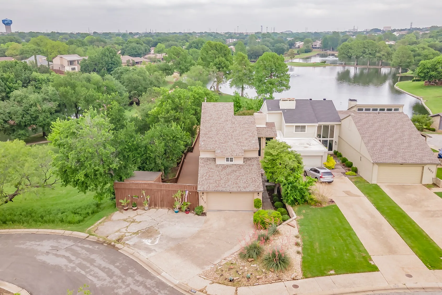 Contemporary residence featuring a prominent front-facing garage, a paved driveway, and a sloped roofline