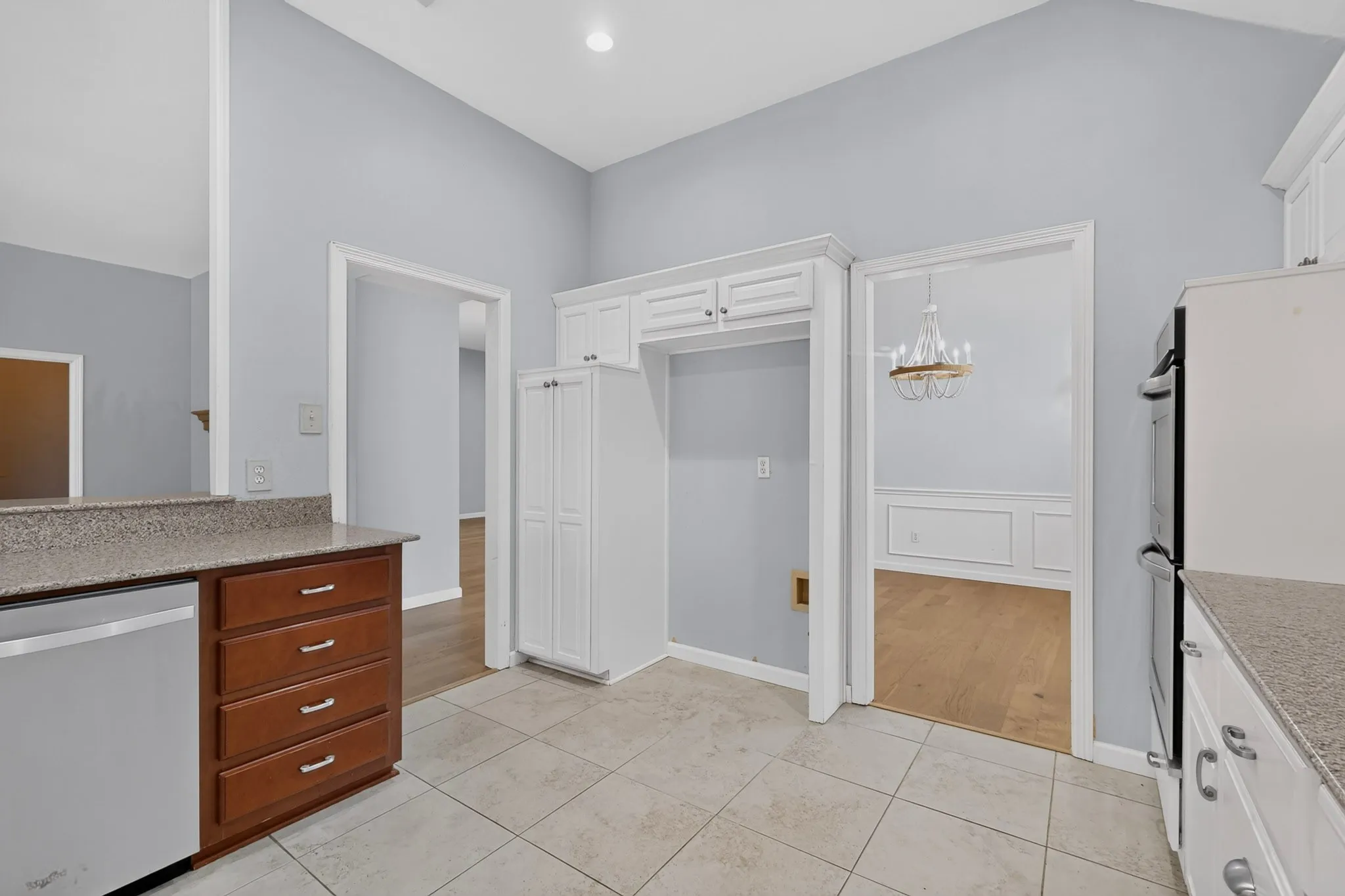 Kitchen featuring tile flooring, vaulted ceiling, and light-toned walls