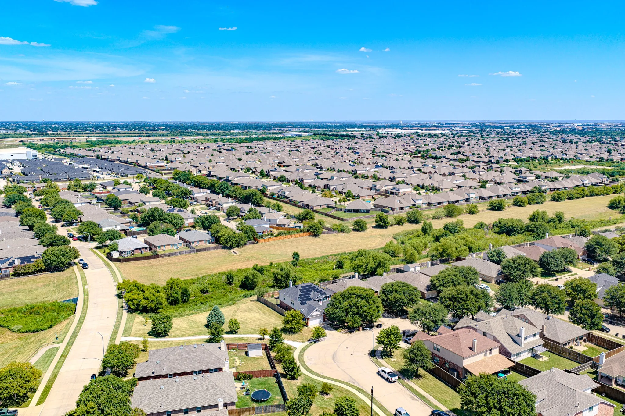 Expansive residential community featuring numerous single-family homes with diverse architectural styles, mature landscaping, and well-maintained streets