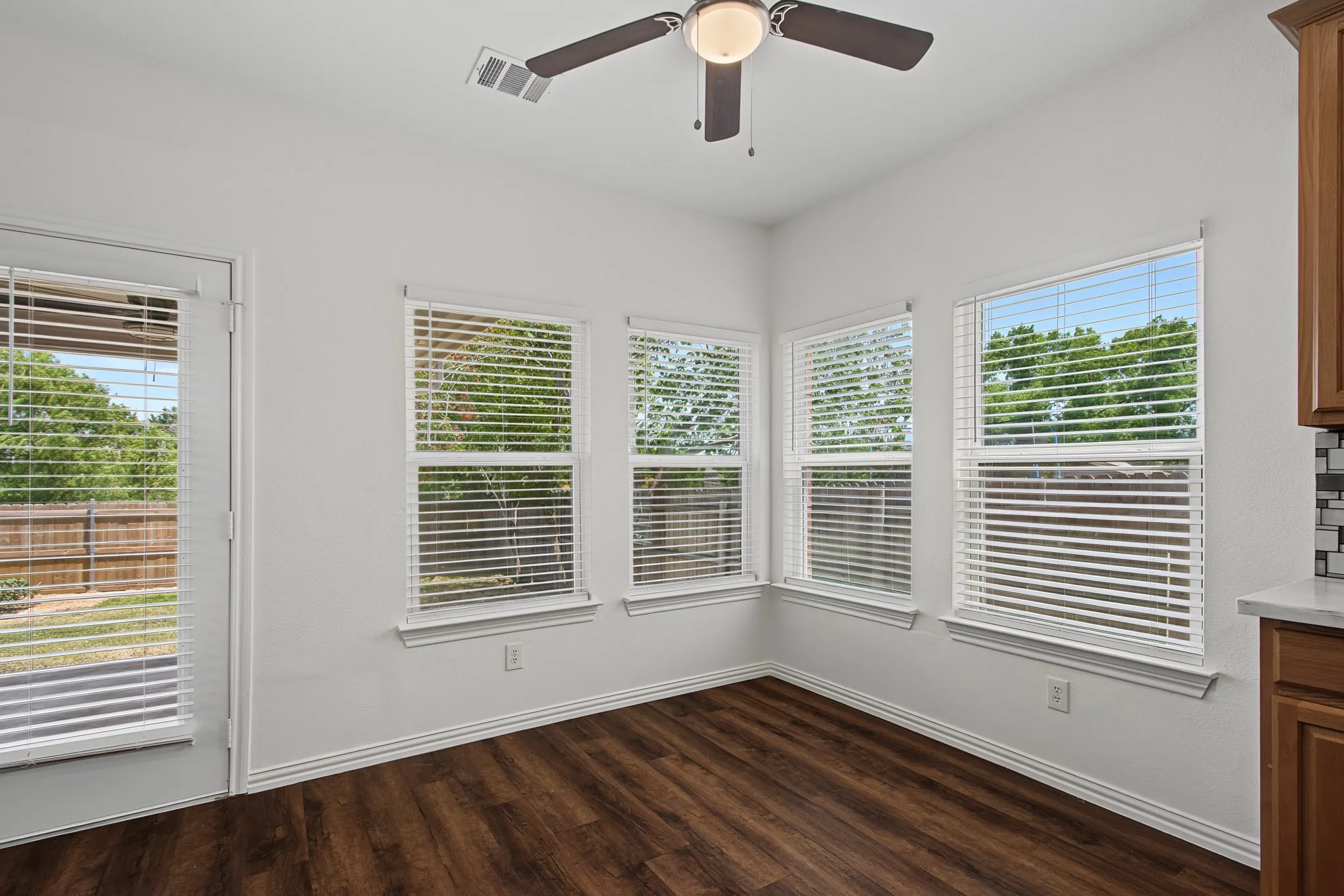 Breakfast nook featuring wood-finish flooring, white walls, and a multi-speed ceiling fan