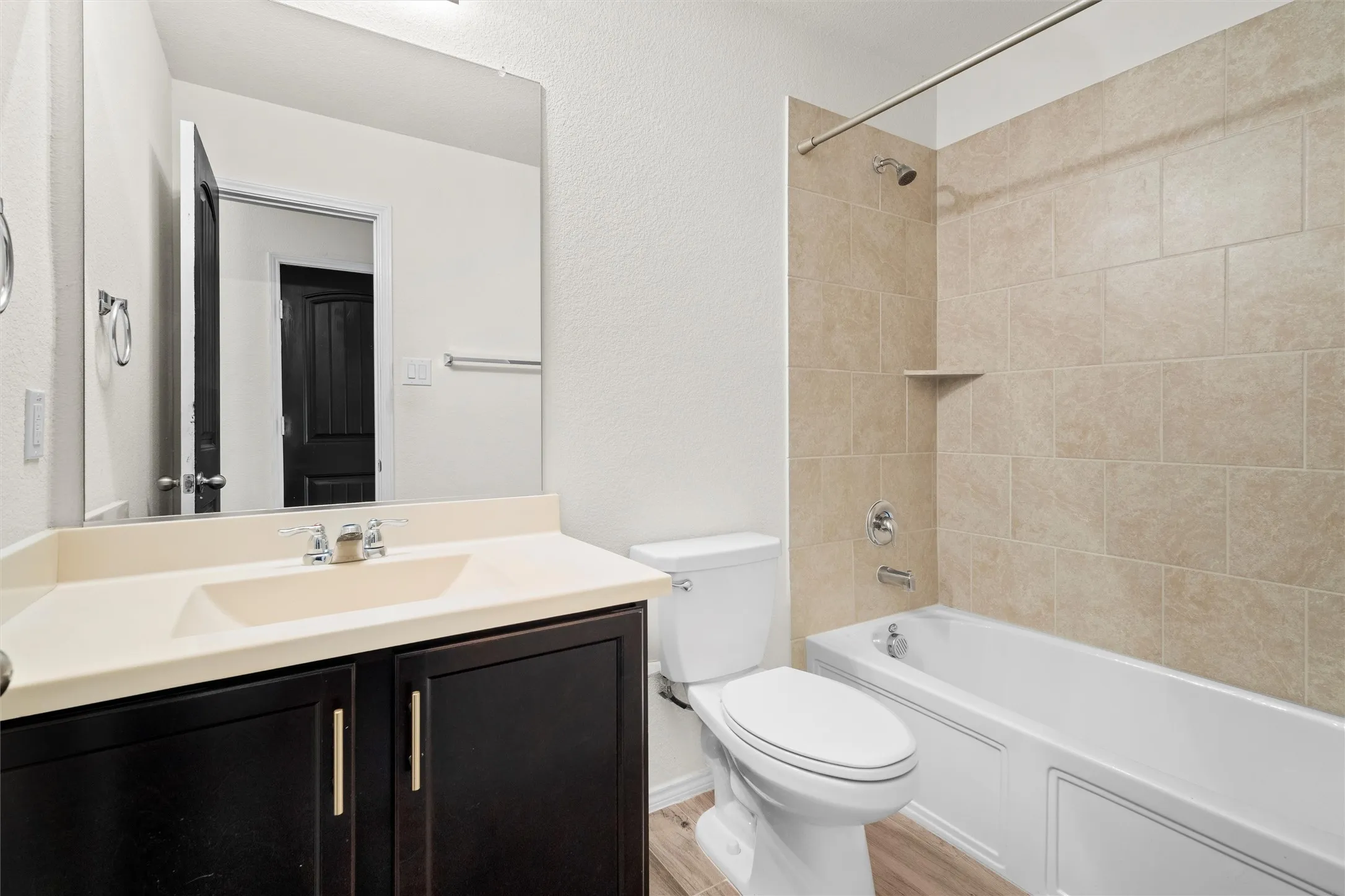 No outdated rental bathrooms here! The secondary bathroom is spotless, featuring a deep soaking tub with a floor-to-ceiling tile surround, a dark vanity with modern gold hardware pulls, and plenty of mirror space to get ready in the morning.
Tags: #BathroomDesign #CleanHome #ModernHardware #RentalLife
