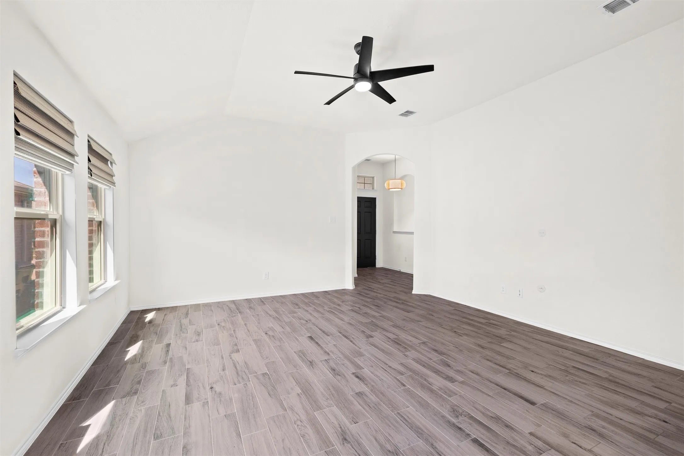 Another view of this incredible living space showing the seamless flow from the entryway. Those custom window shades give you total privacy when you want it, and the pristine, neutral walls are a blank canvas just waiting for your personal touch.  #MoveInReady #InteriorDesign #SpaciousLiving #CleanAesthetic