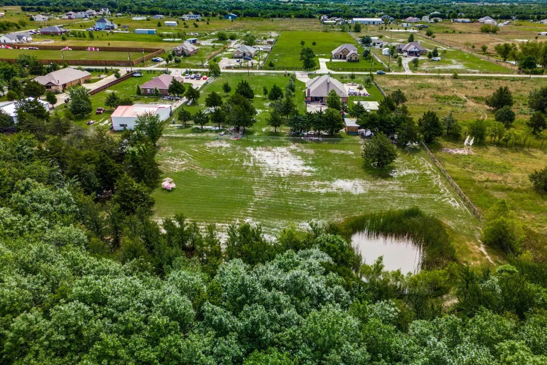 Expansive acreage featuring a natural pond, surrounding greenery, and cleared land