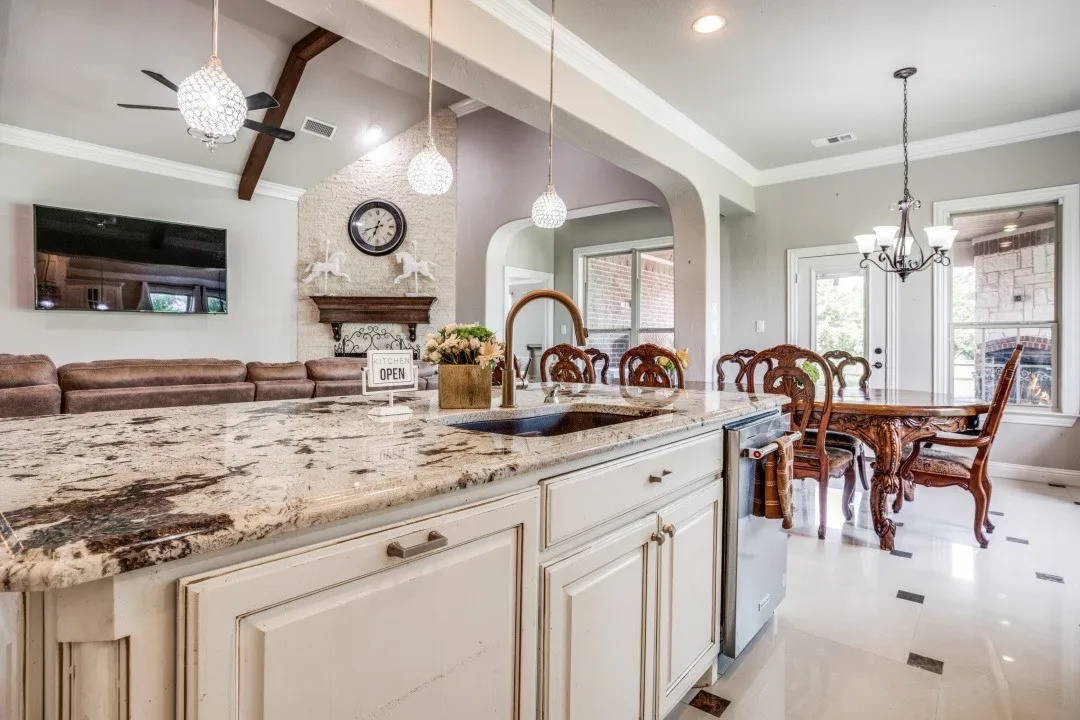 Kitchen island featuring a granite countertop with integrated sink and chrome faucet