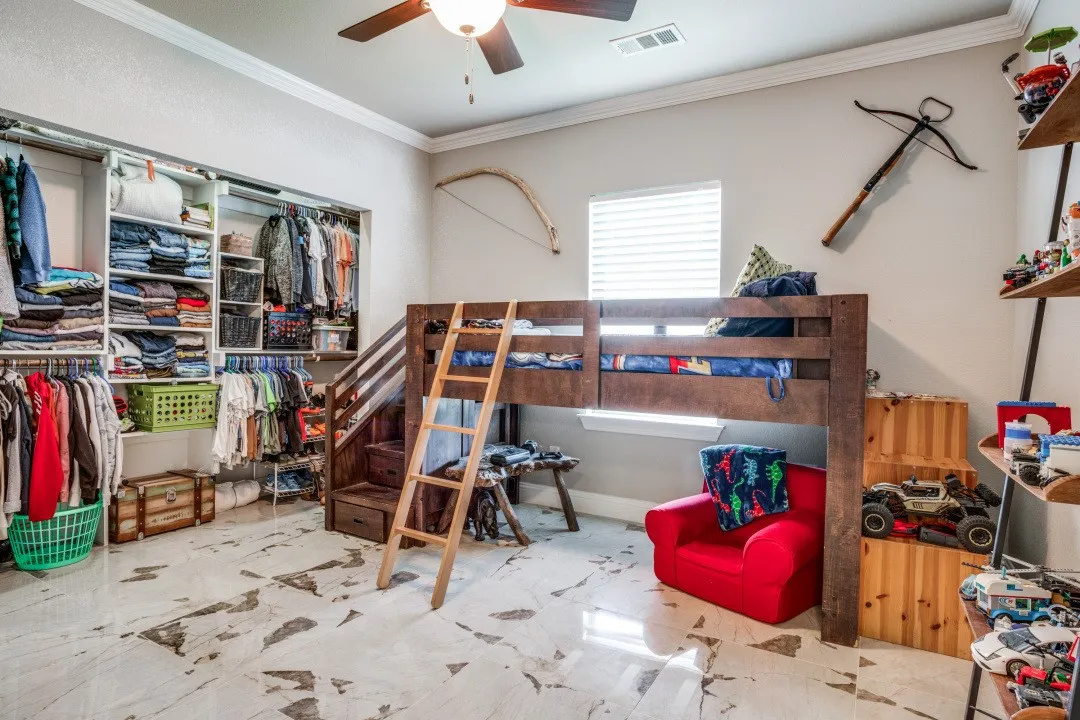 Custom built-in storage solutions and a loft bed with integrated stairs define this versatile room