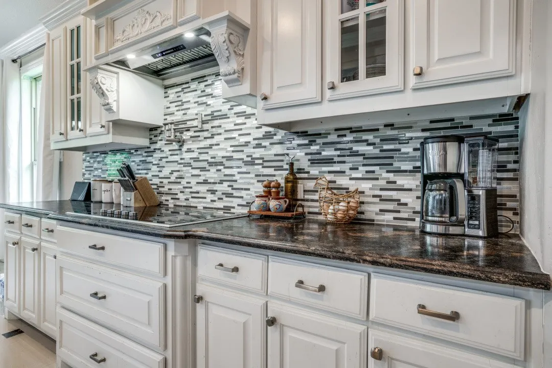 White cabinetry with decorative corbels and glass-front upper cabinets