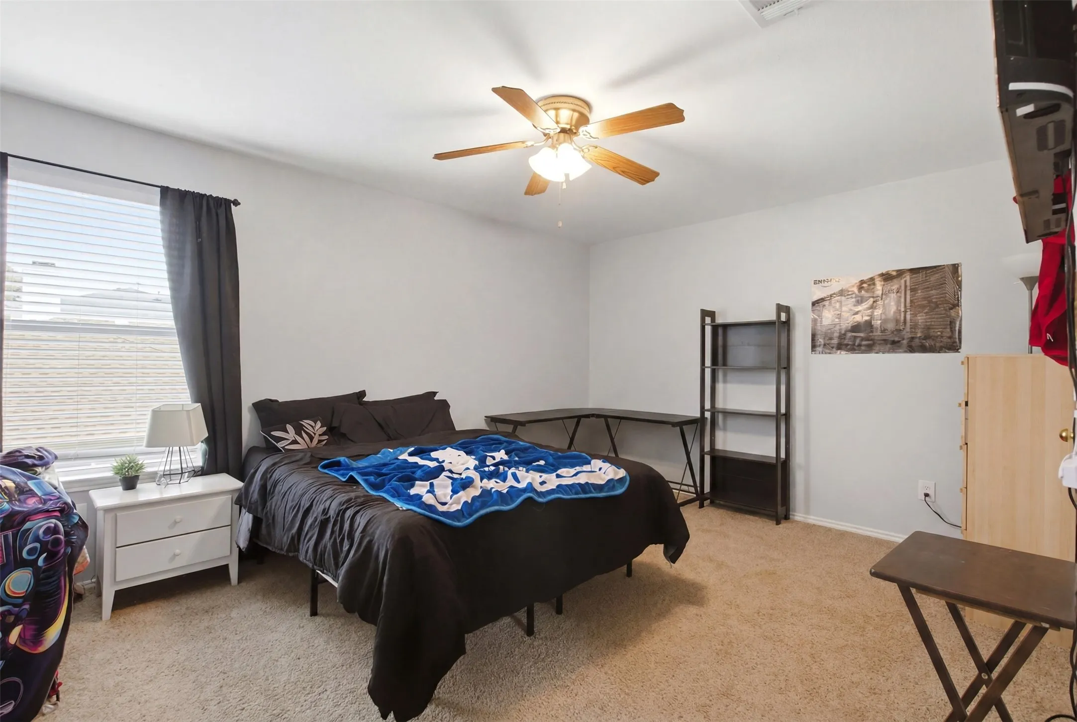 Carpeted room with a ceiling fan light fixture