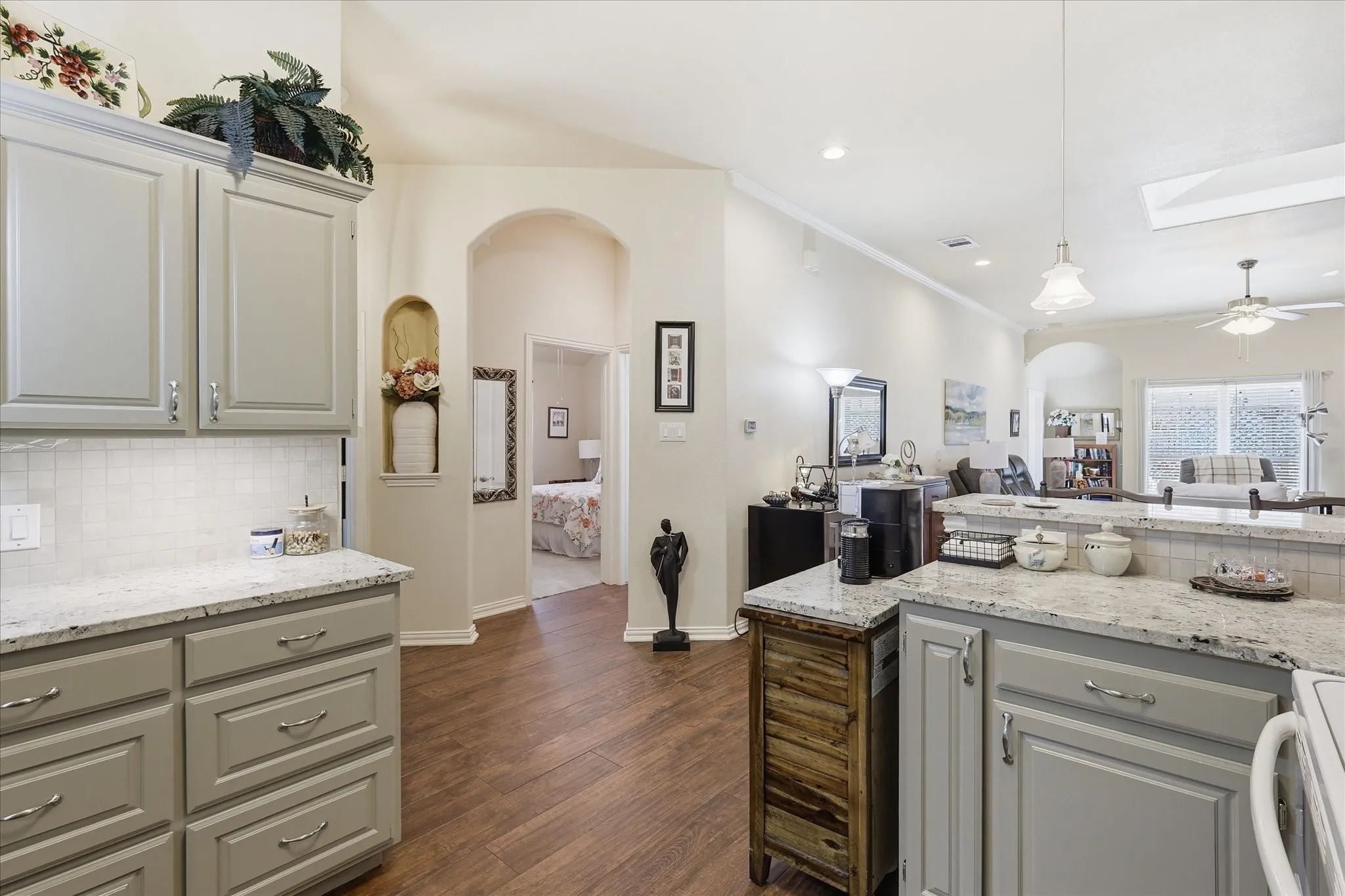 Kitchen featuring light-toned cabinetry, granite countertops, and a subway tile backsplash