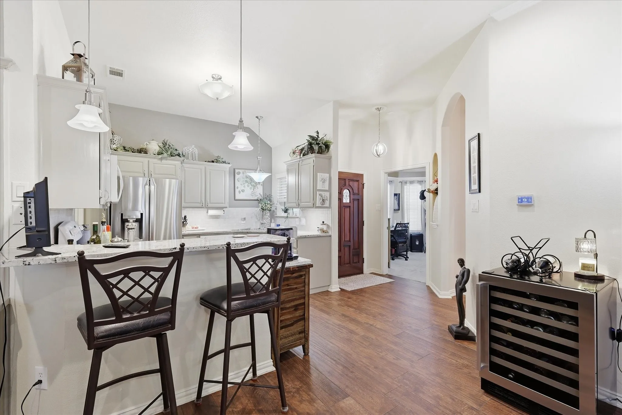 Kitchen featuring light-toned cabinetry, granite countertops, and a subway tile backsplash