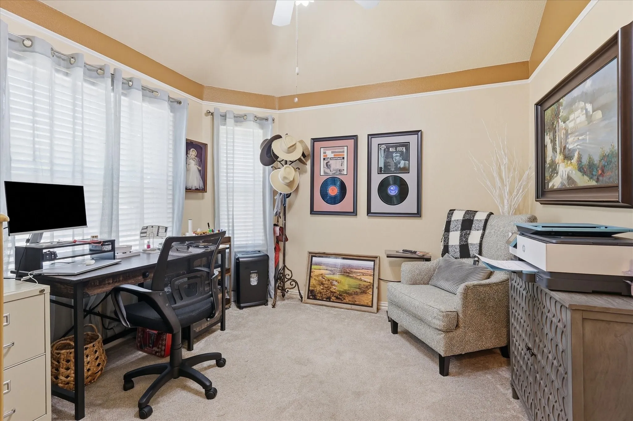 Carpeted room featuring a ceiling fan, bay window with blinds, and neutral wall tones
