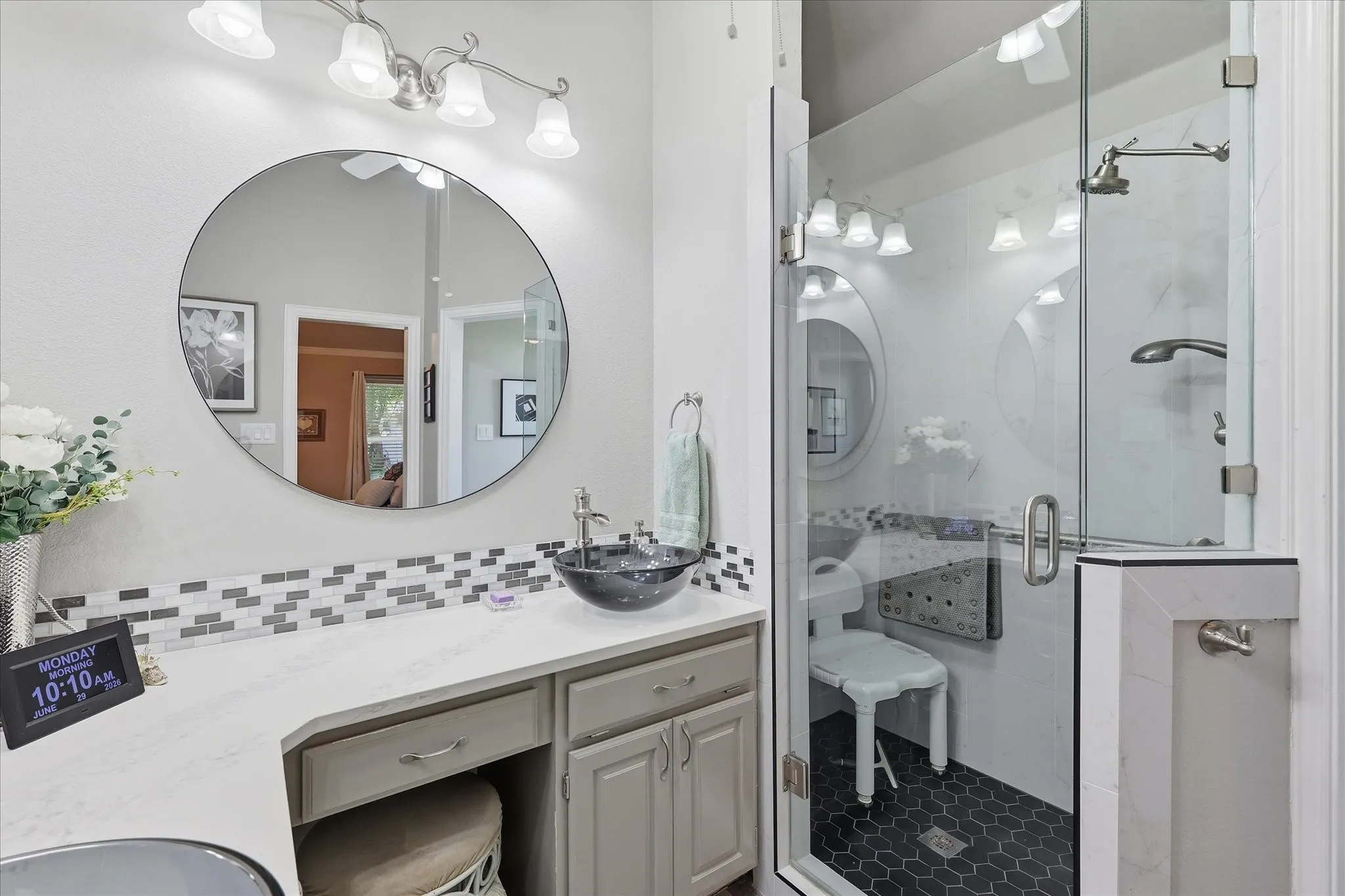 Contemporary bathroom featuring a spacious glass-enclosed shower with dual shower heads and a dark hexagonal tile floor
