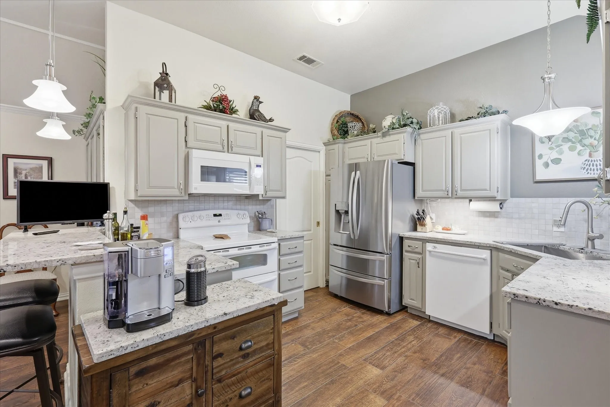 Kitchen featuring light-toned cabinetry, granite countertops, and a subway tile backsplash
