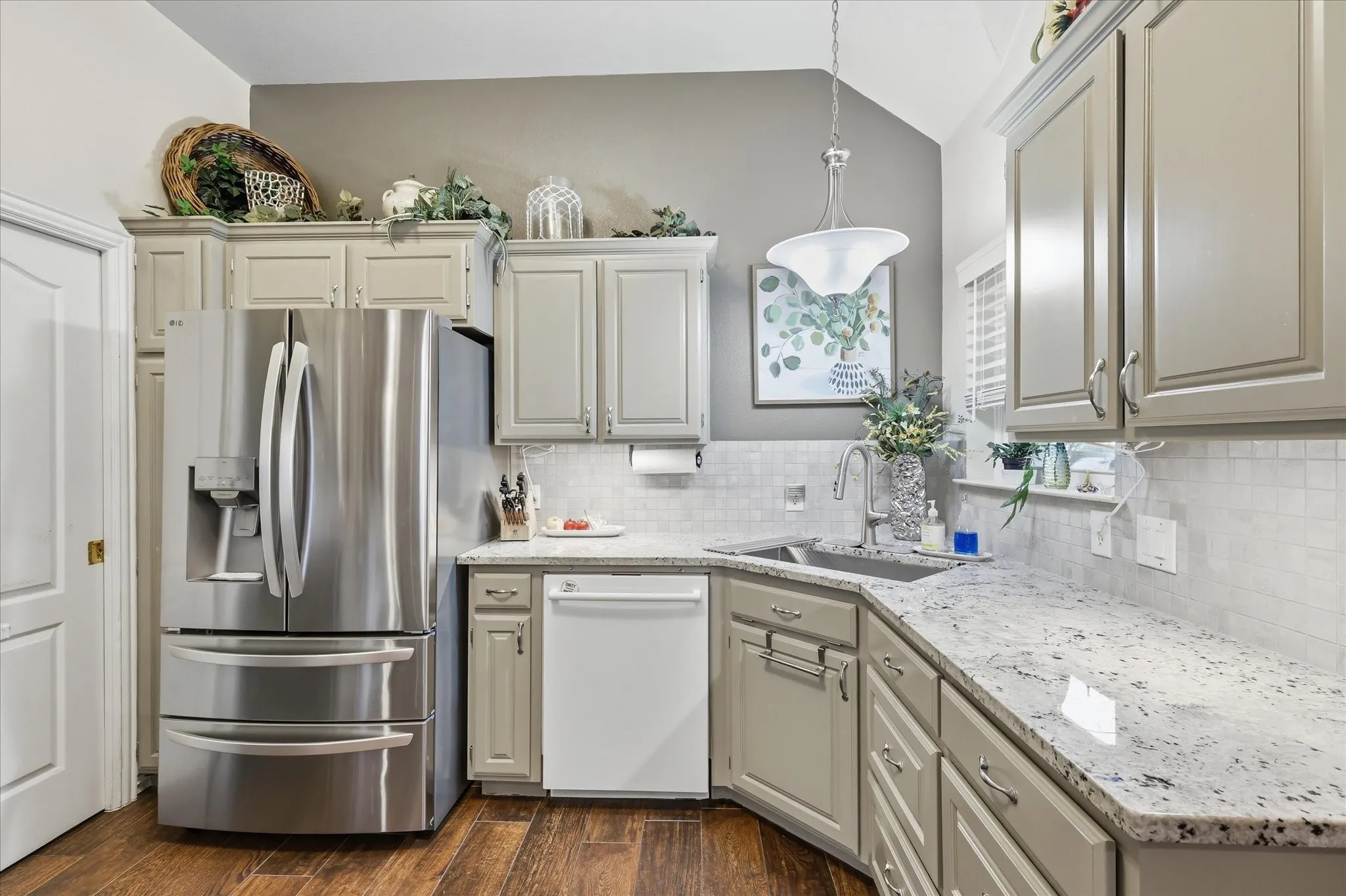 Kitchen featuring light-toned cabinetry, granite countertops, and a subway tile backsplash