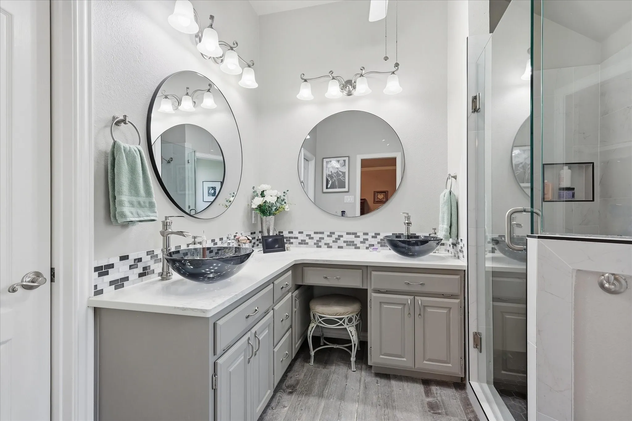 Dual vessel sinks with coordinating fixtures, set into a white countertop with a tiled backsplash