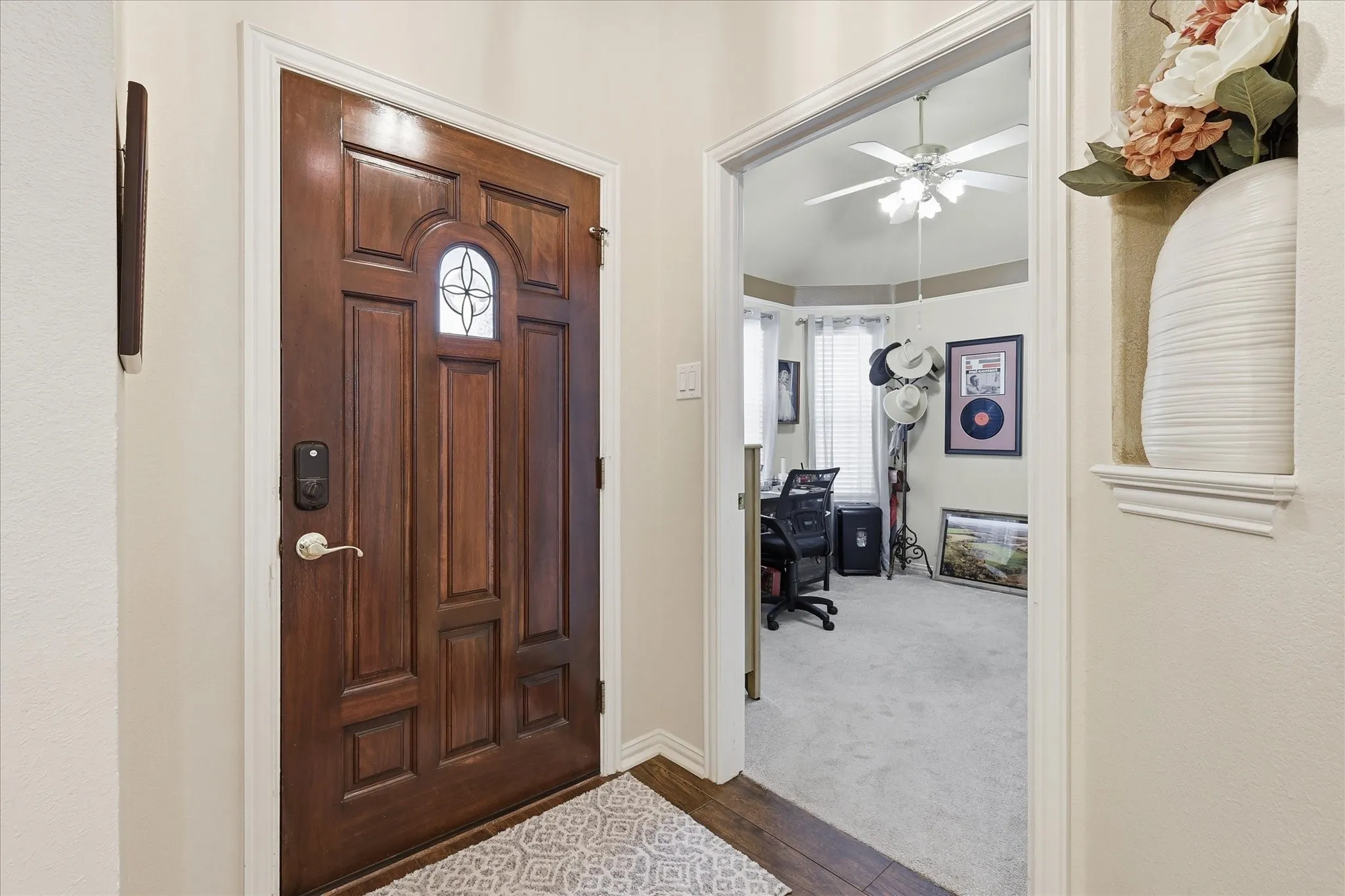 Solid wood-panel front door with decorative glass inlay and smart lock hardware