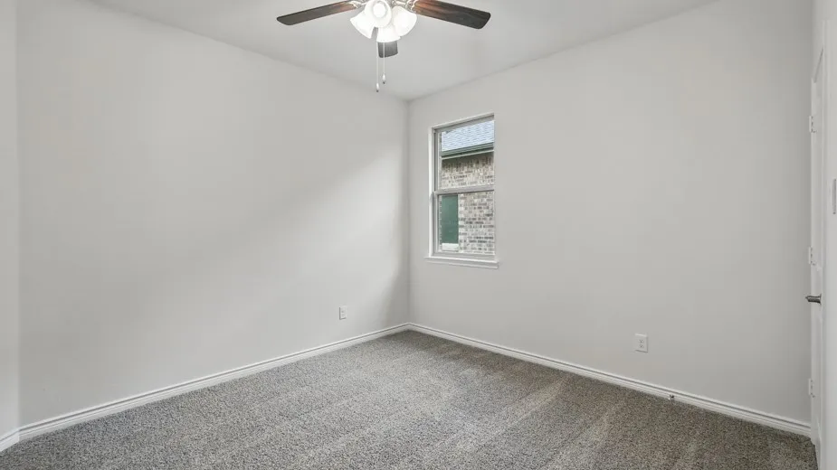 Carpeted room with a ceiling fan, a window, and light-colored walls