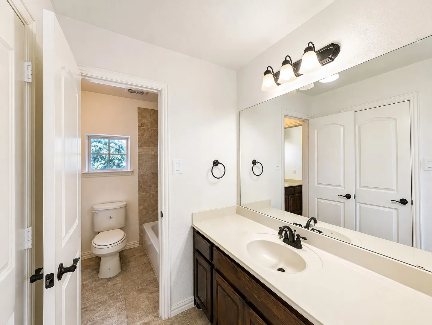 Bathroom vanity featuring a light-toned countertop, integrated sink, and dark wood-finish cabinetry