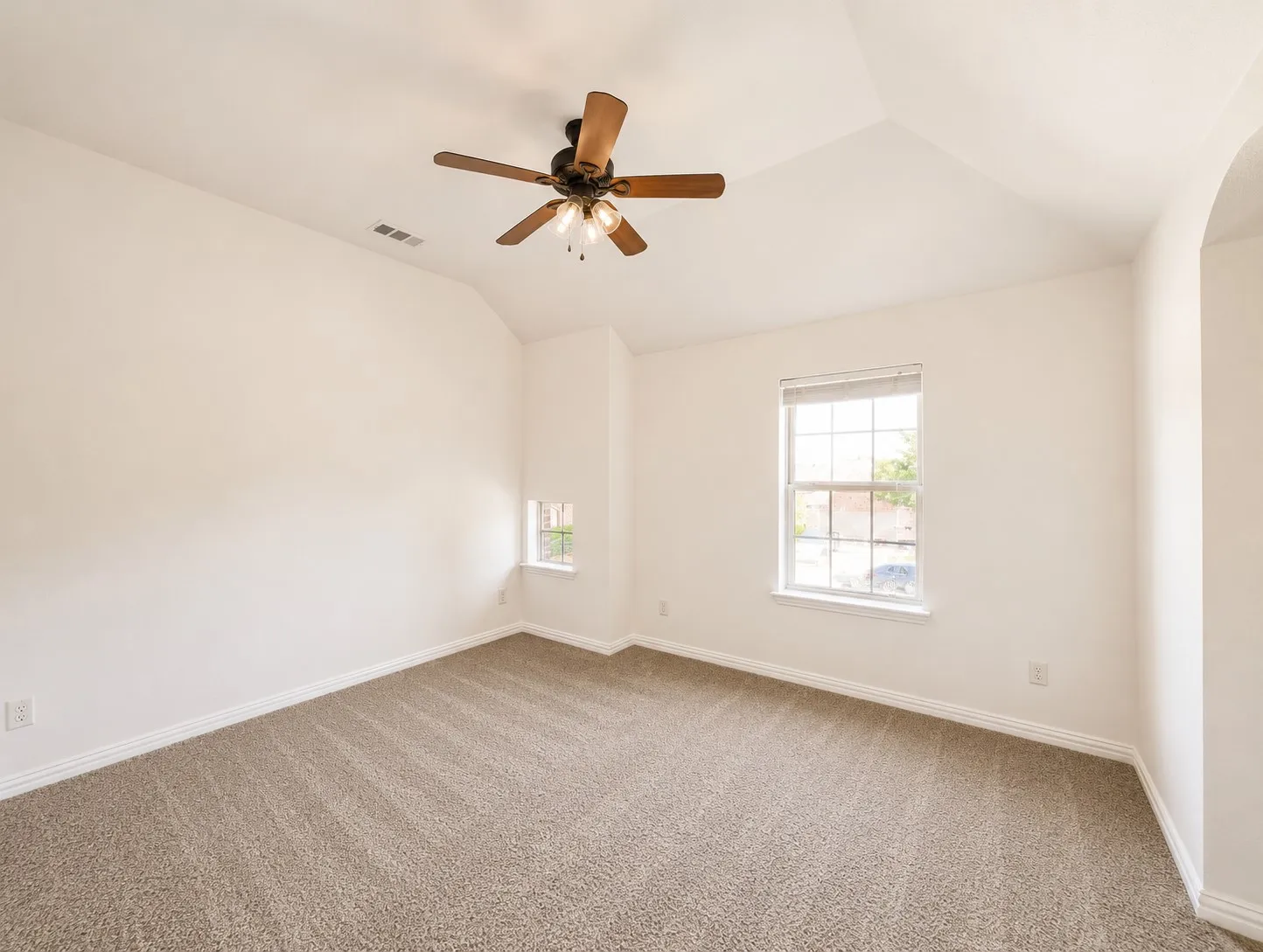 Vaulted ceiling with a wood-finish ceiling fan and light fixture