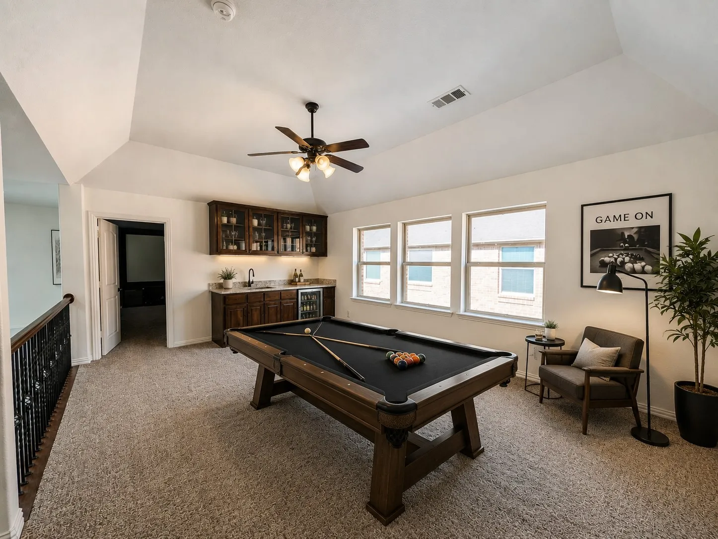 Carpeted bonus room with a built-in wet bar, recessed lighting, and multiple windows - Virtually staged