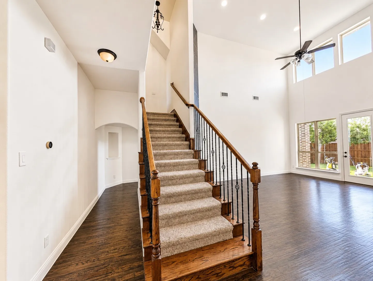 Two-story living area featuring high ceilings with recessed lighting, a ceiling fan, and large windows