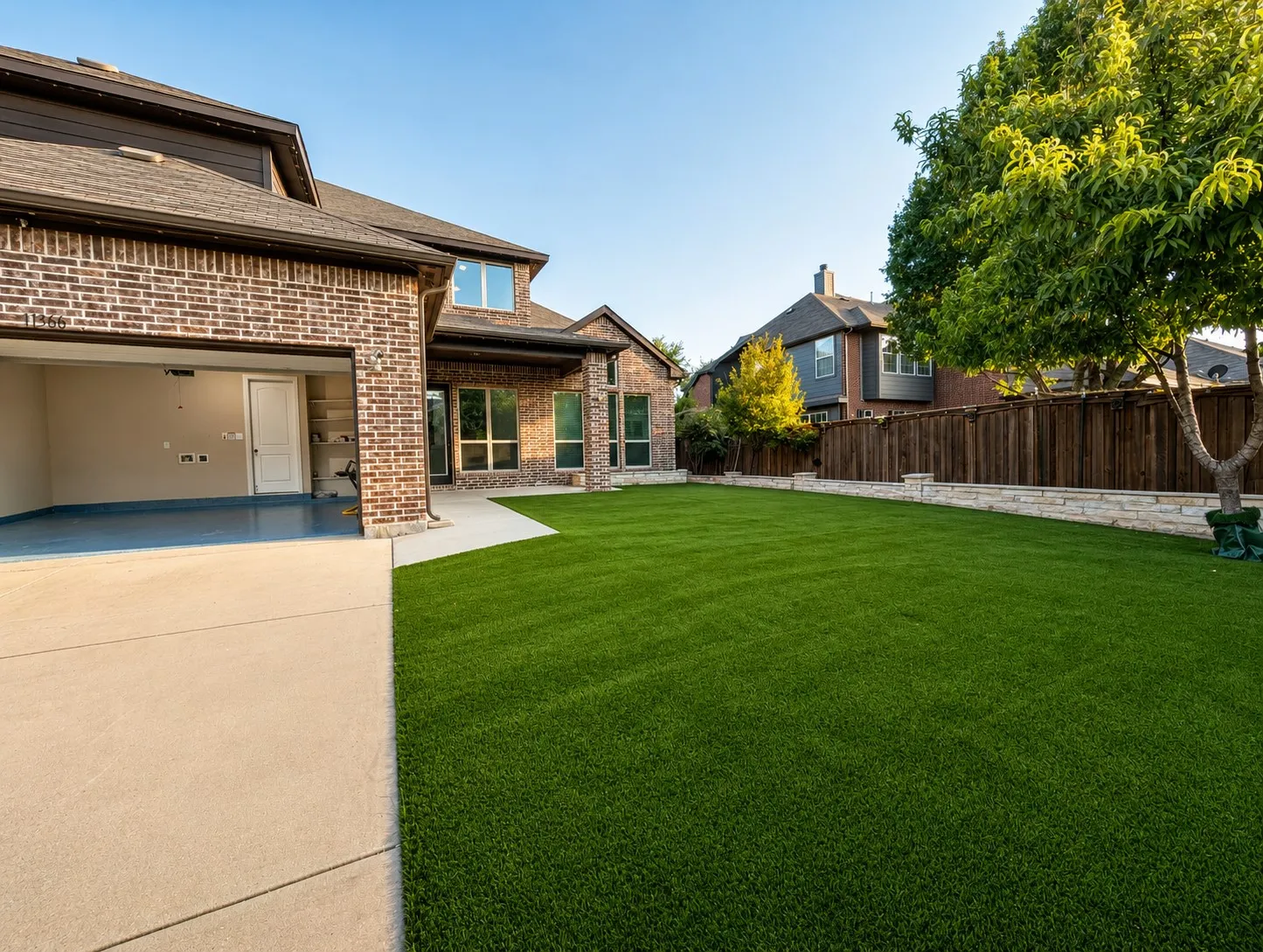 Expansive green lawn with a stone retaining wall