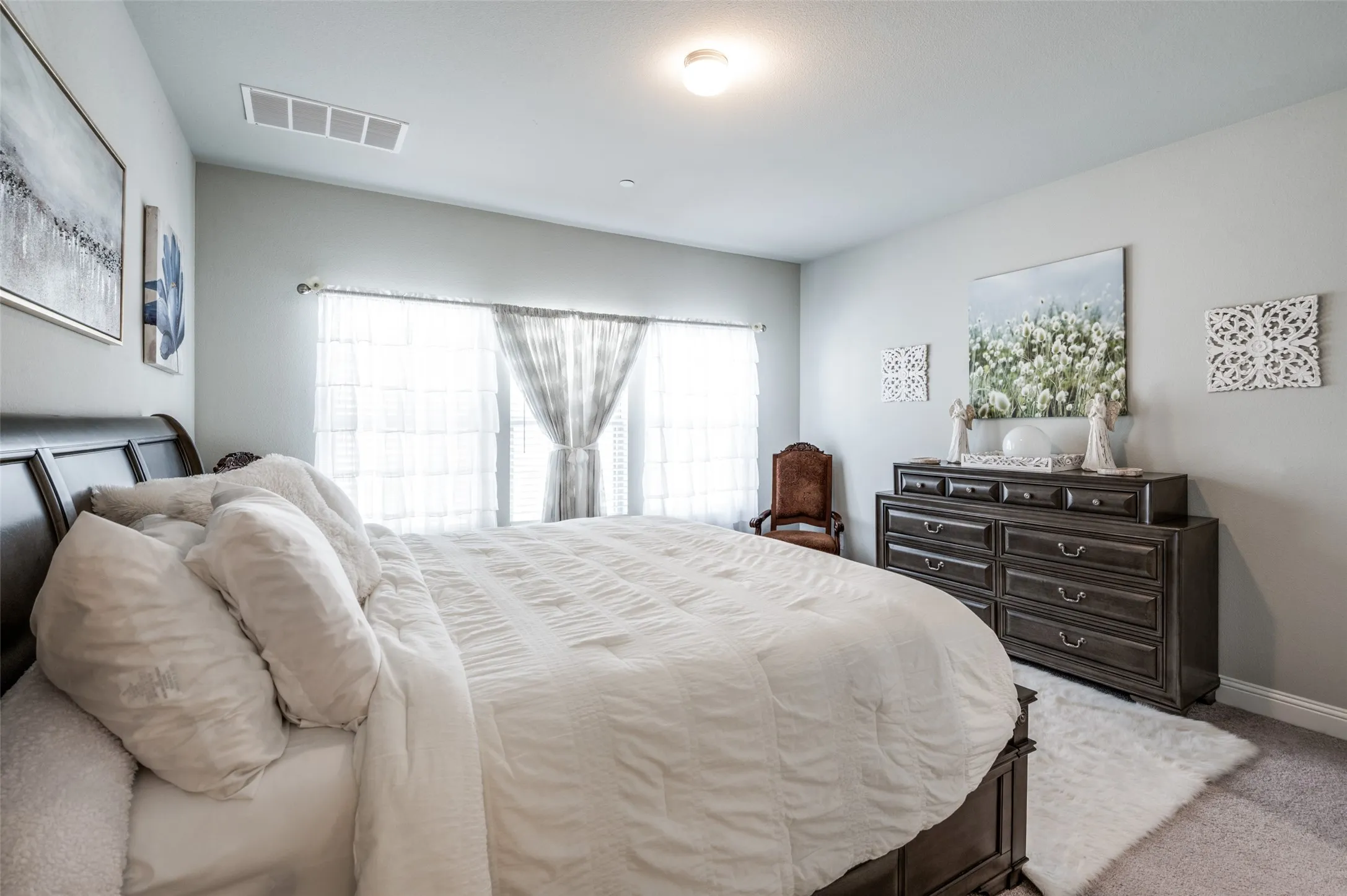 Spacious room with light gray wall paint and light-colored carpet flooring