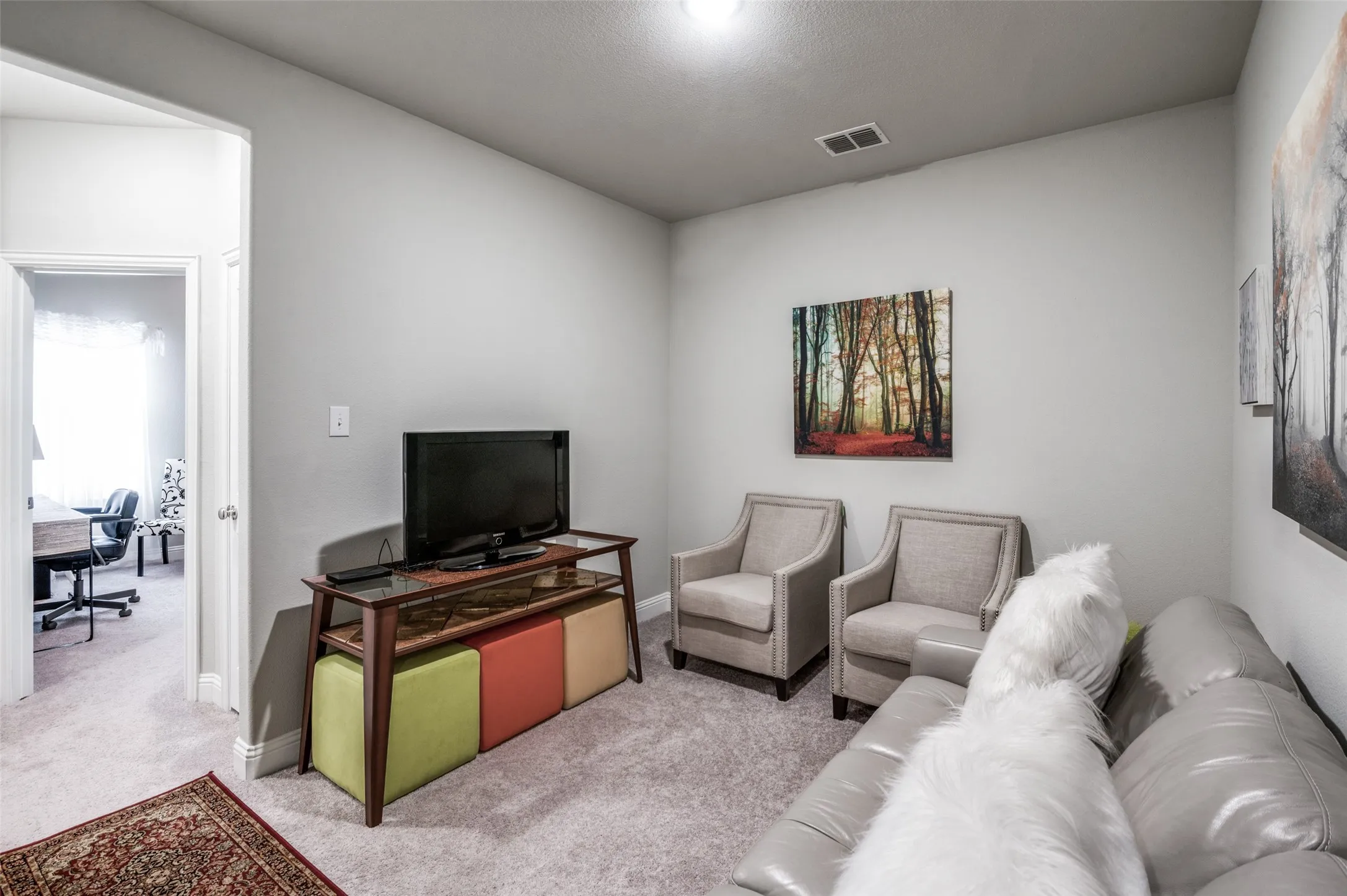 Carpeted room with light gray walls, an open doorway, and a ceiling light fixture