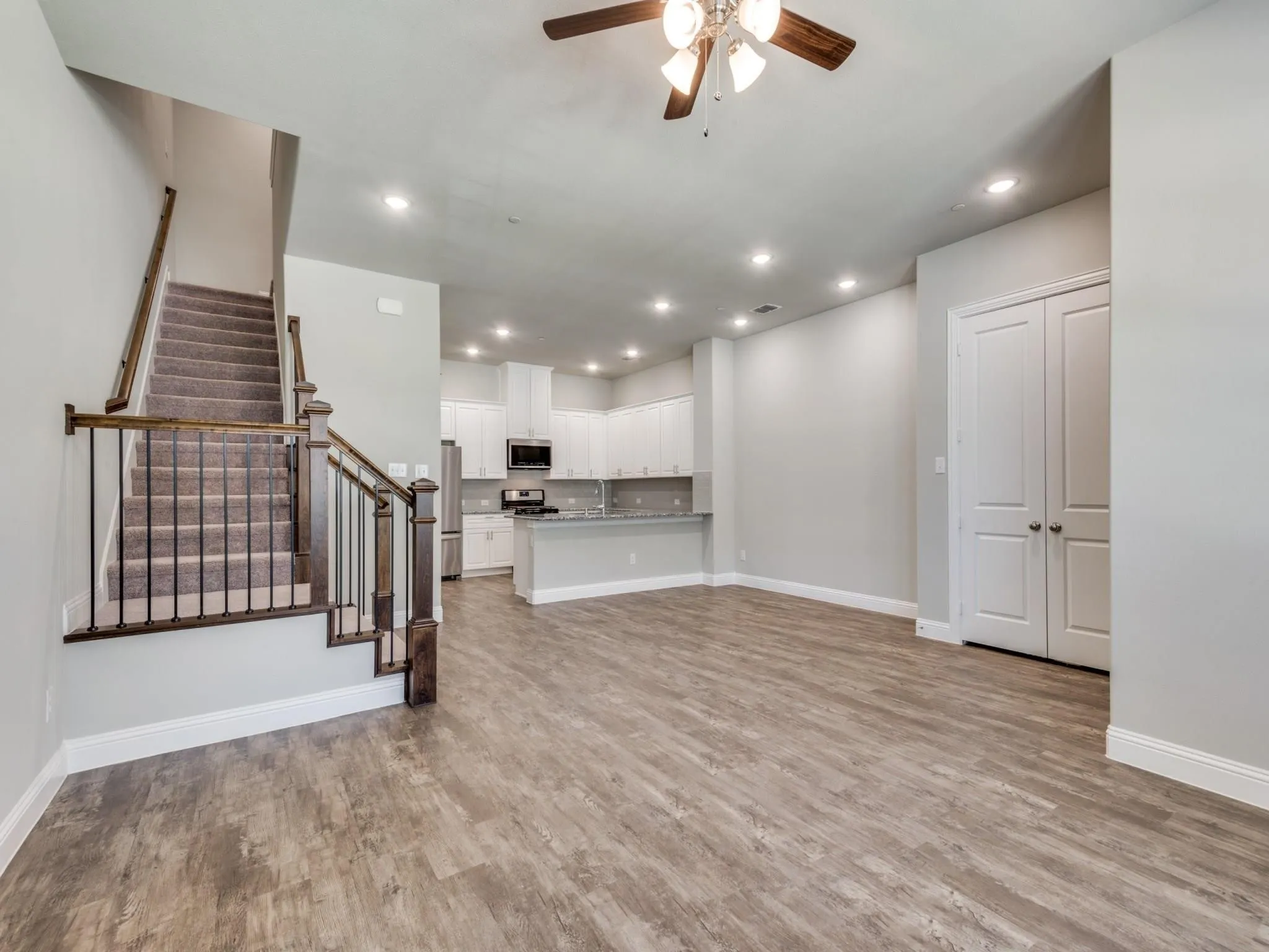 Open-concept living area featuring wood-finish flooring, recessed lighting, and a ceiling fan