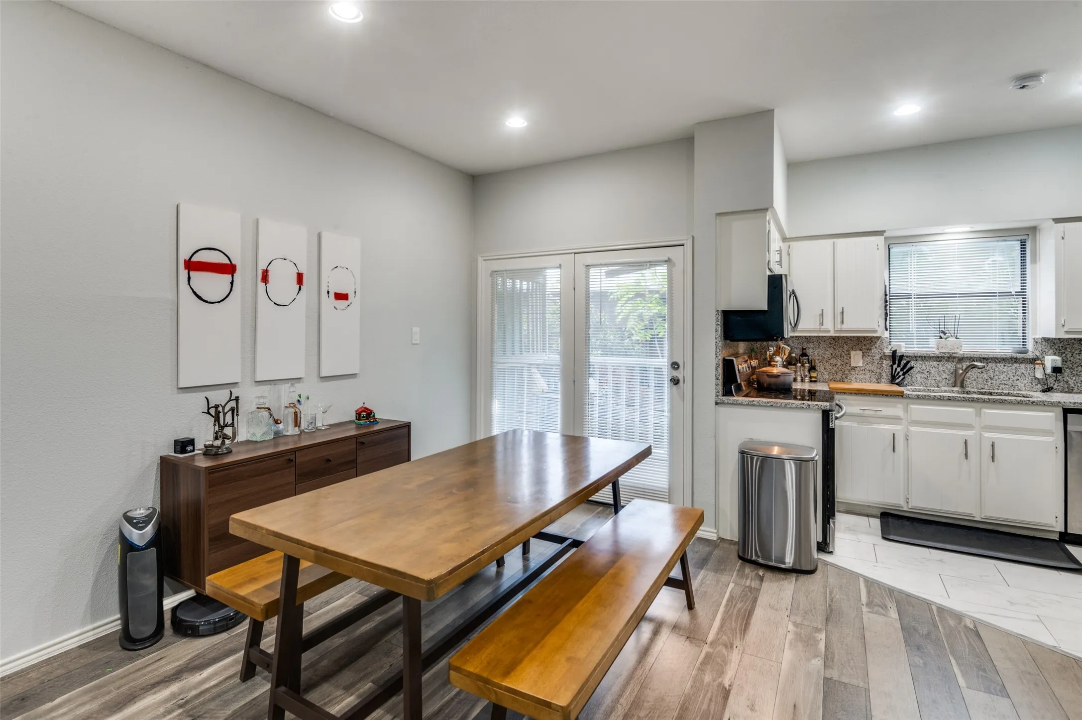 Kitchen and dining area featuring white cabinetry, granite countertops, and stainless steel appliances