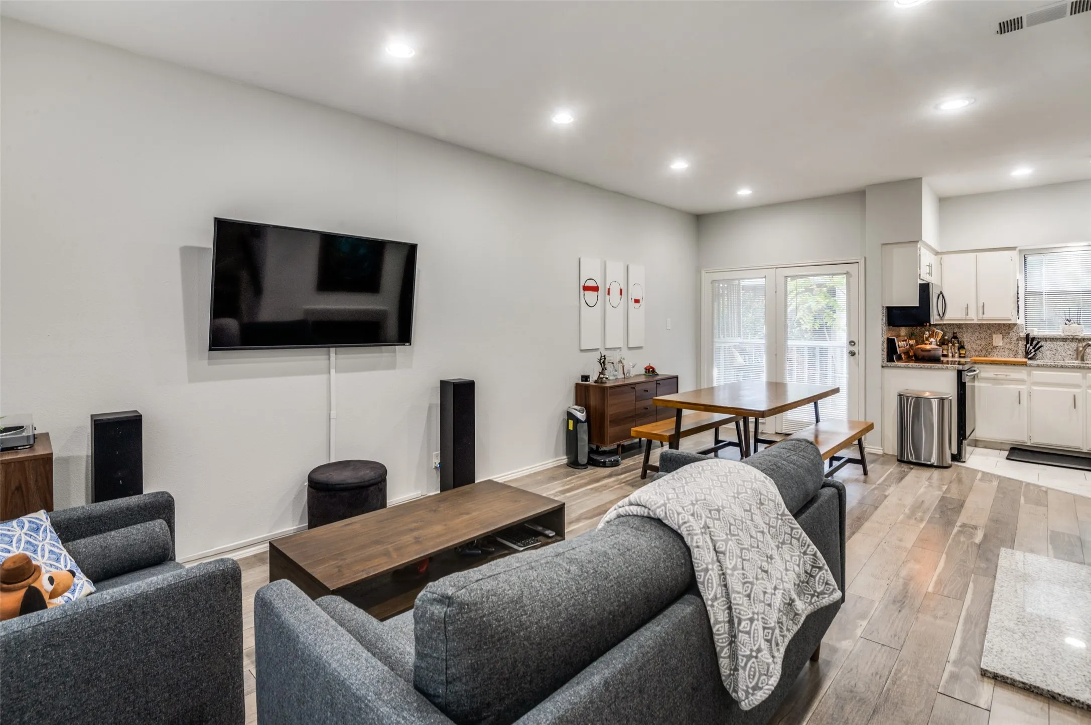 Open-concept living space featuring wood-finish flooring, recessed lighting, and light-toned walls
