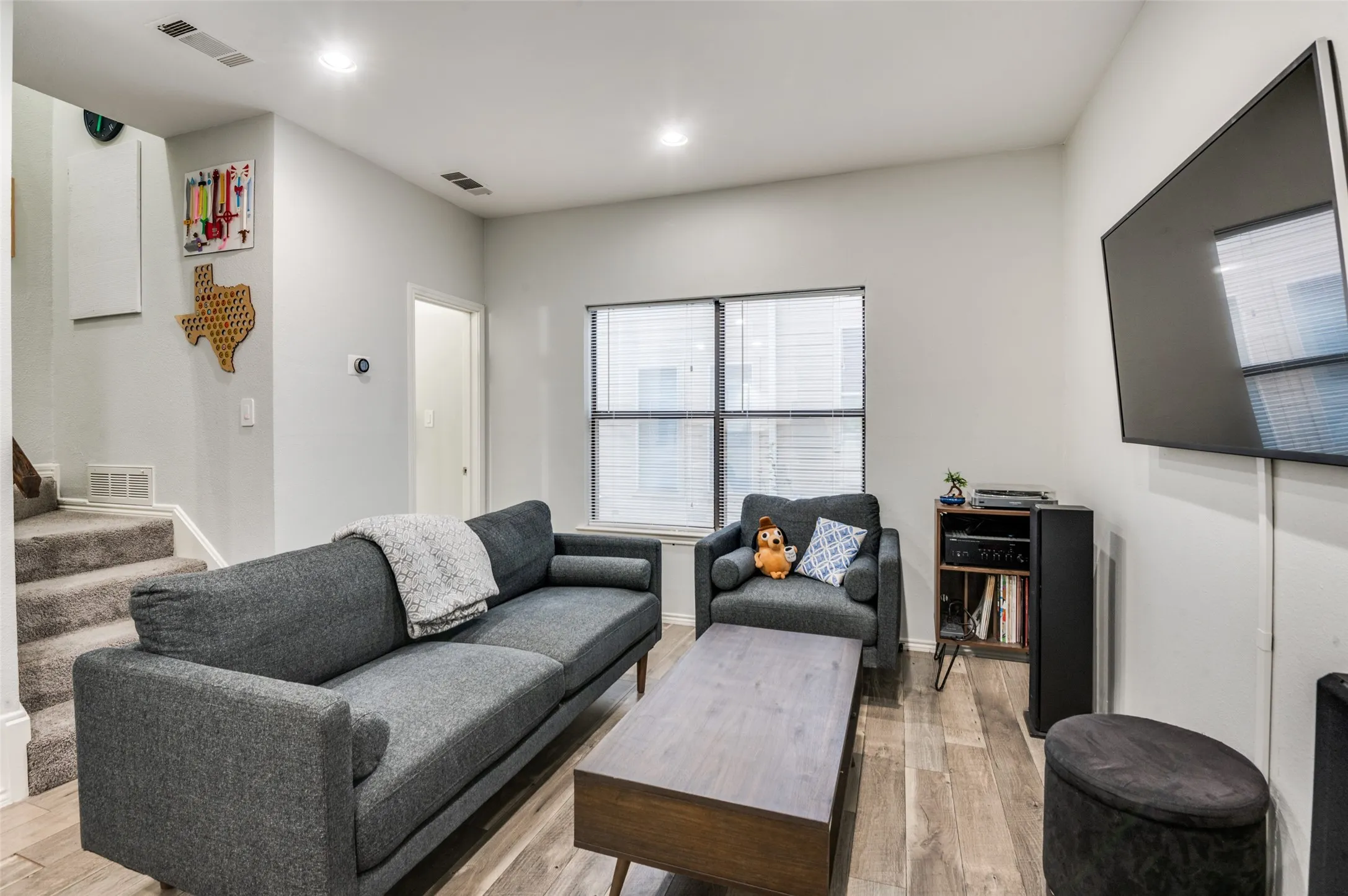 Living space featuring wood-finish flooring, recessed lighting, and a neutral wall palette