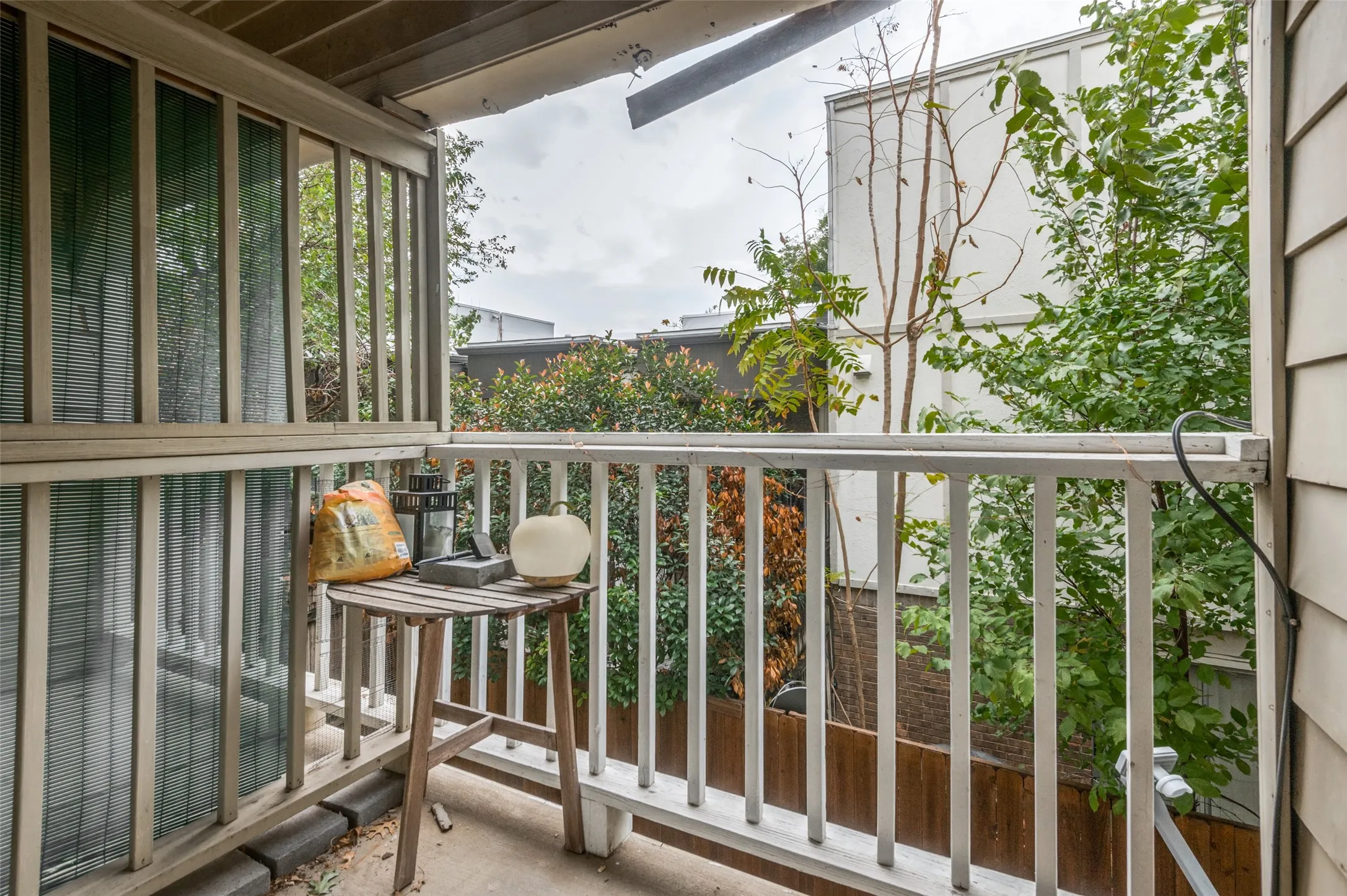 Private balcony with white painted railings and concrete flooring
