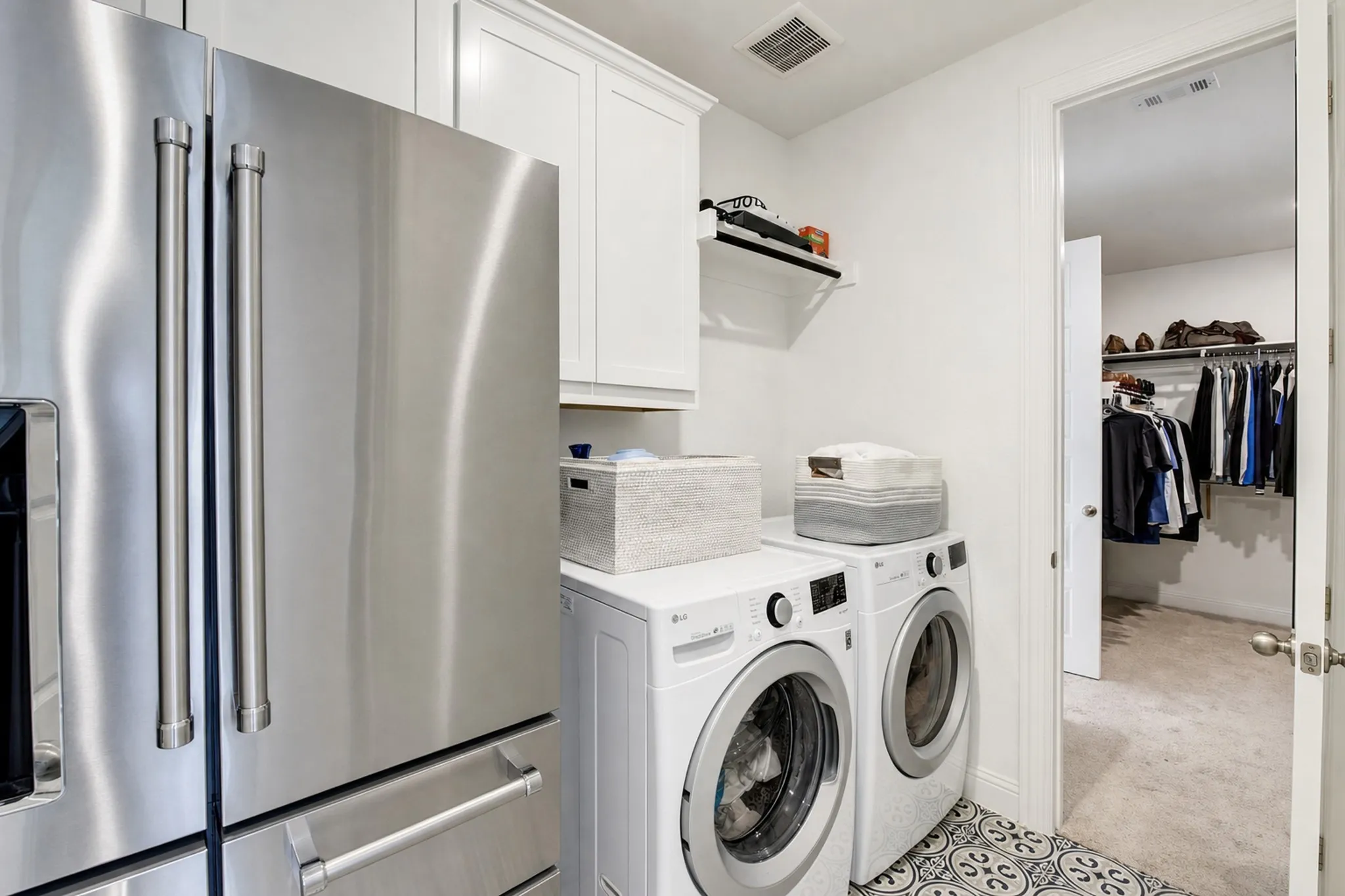 The laundry room, with space for a second fridge, conveniently connects to the walk-in closet in the primary bedroom.